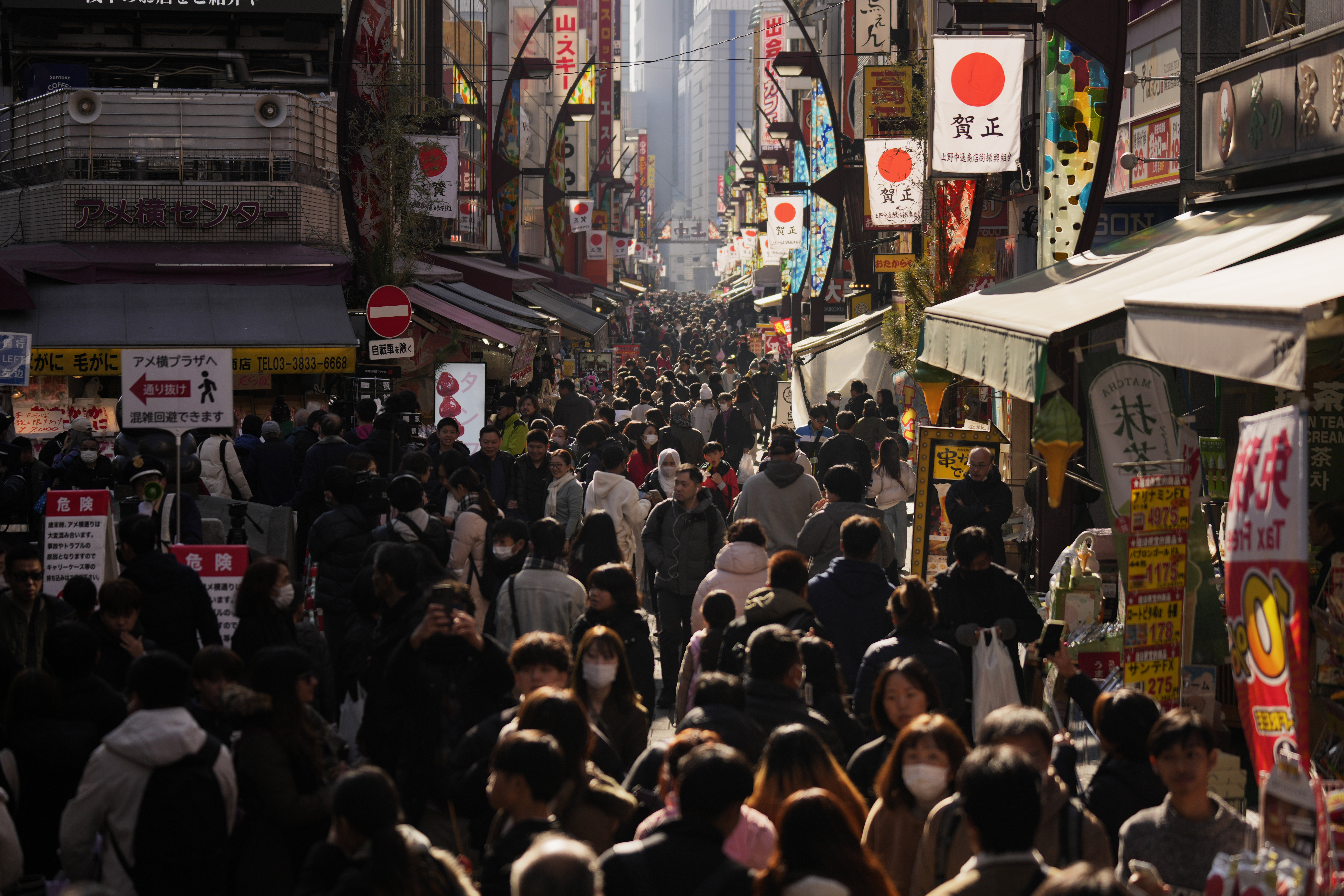 People crowd the famed "Ameyoko" shopping street on New Year's Eve in Tokyo, Tuesday, Dec. 31