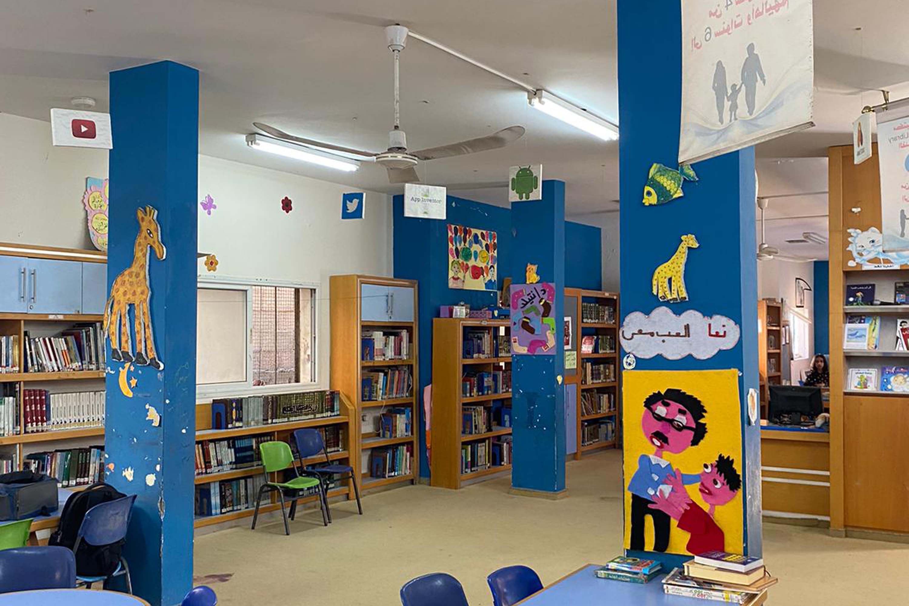 a photo of a library with bookshelves and chairs
