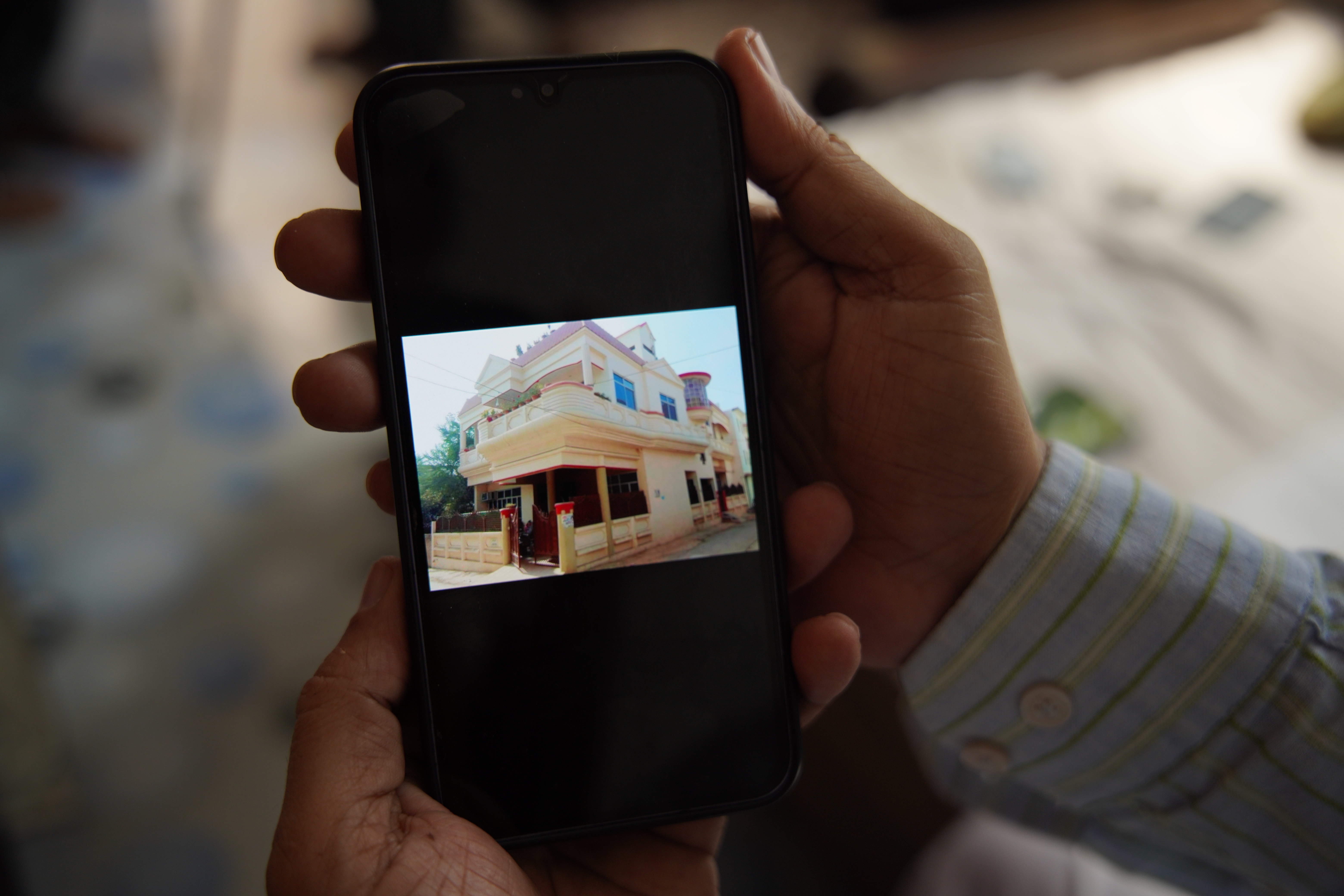 Muslim activist Javed Mohammed showing a photo of his house before it was demolished [Shivangi Mariam Raj/Al Jazeera]