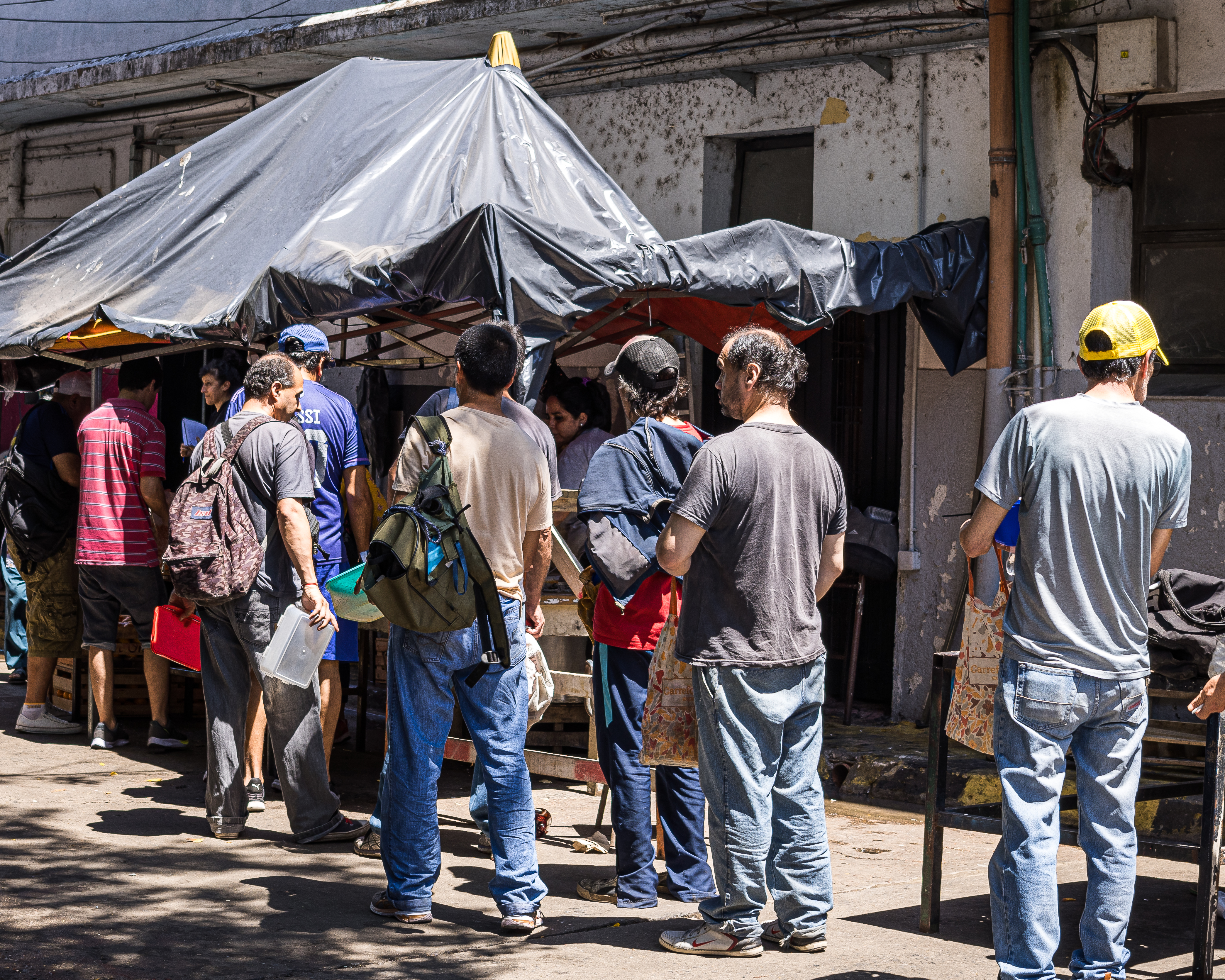People queue up outside the Constitucion train station in Buenos Aires for food at a soup kitchen.