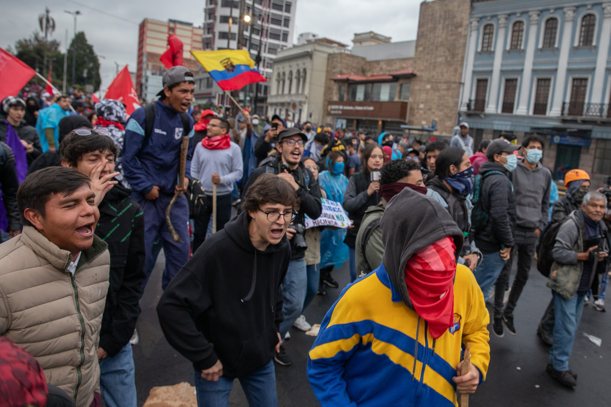 Protesters wave Ecuadorian flags during an outdoor demonstration in Quito