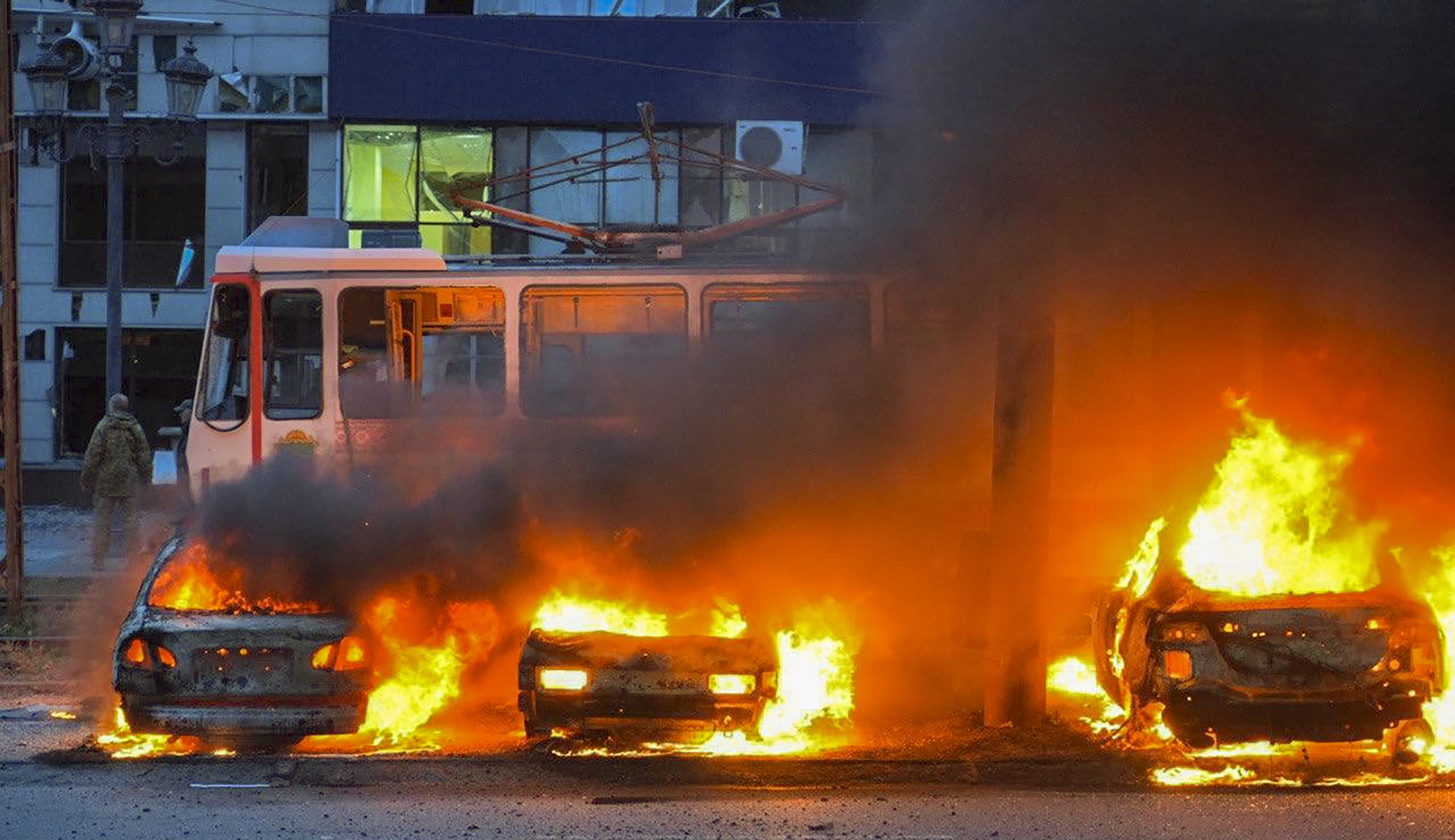 burning cars in front of a tram