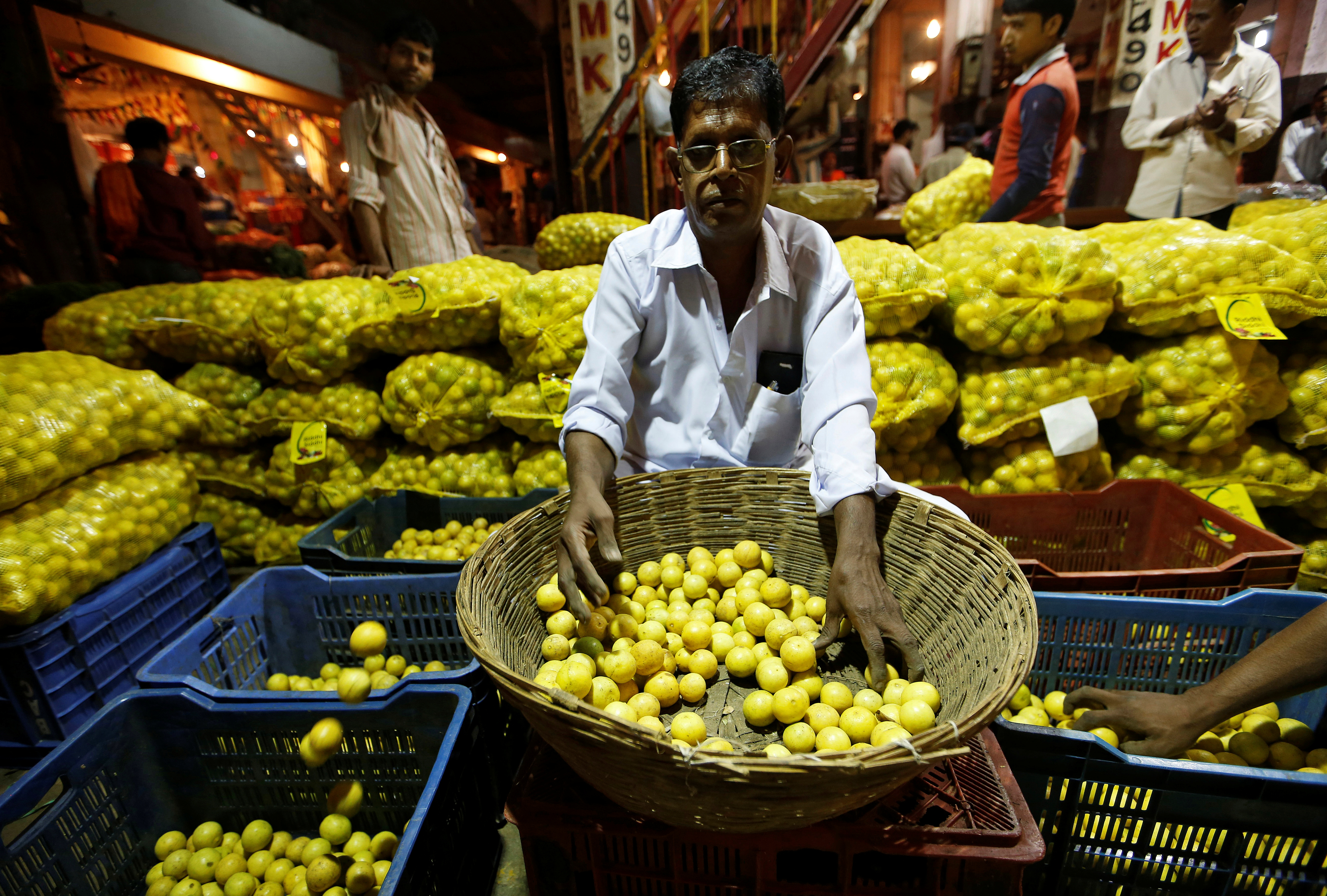 A worker sorts lemons at a wholesale market in Mumbai, India