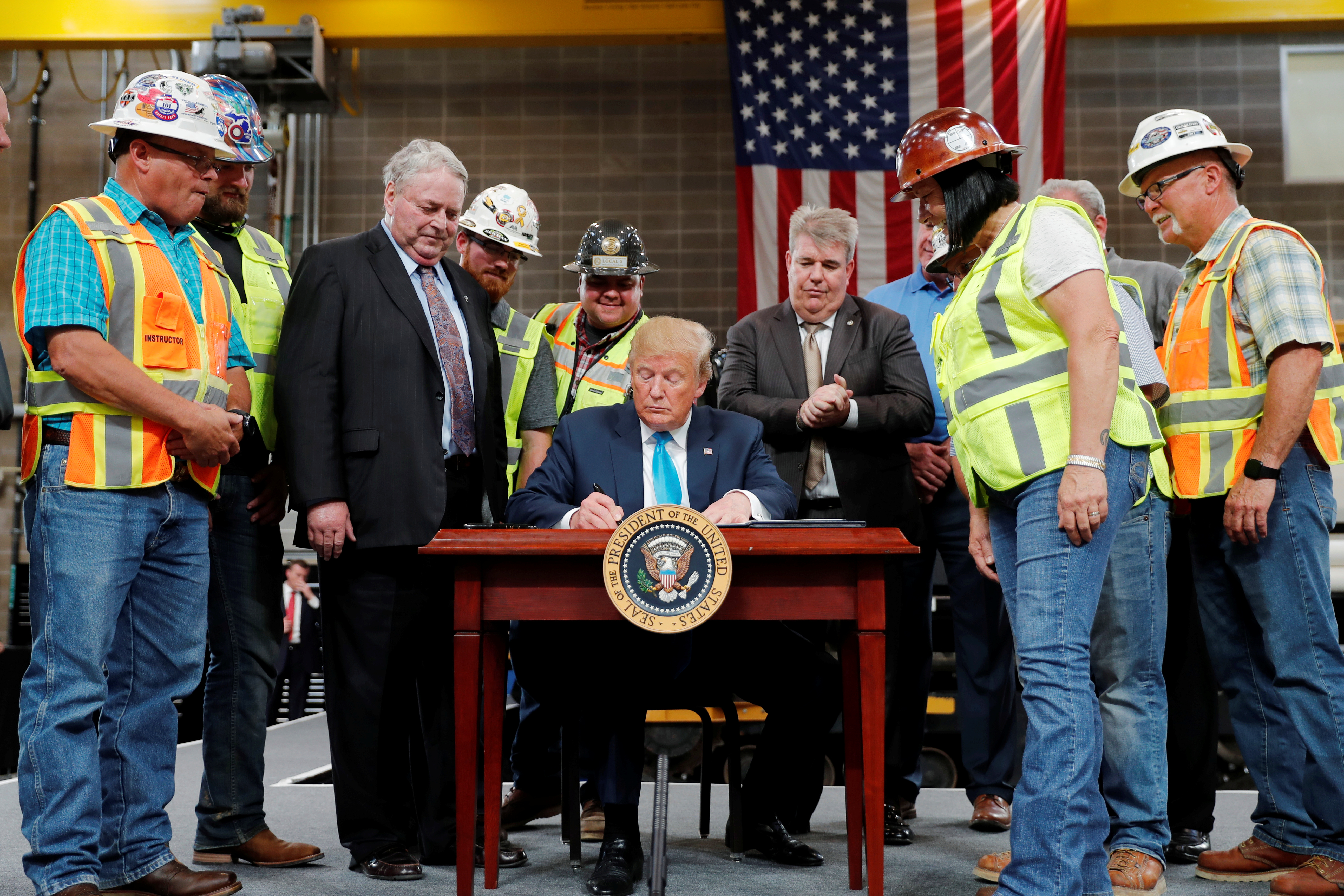 U.S. President Donald Trump signss an executive order on energy and infrastructure during a campaign event at the International Union of Operating Engineers International Training and Education Center in Crosby, Texas, U.S., April 10, 2019. REUTERS/Carlos Barria