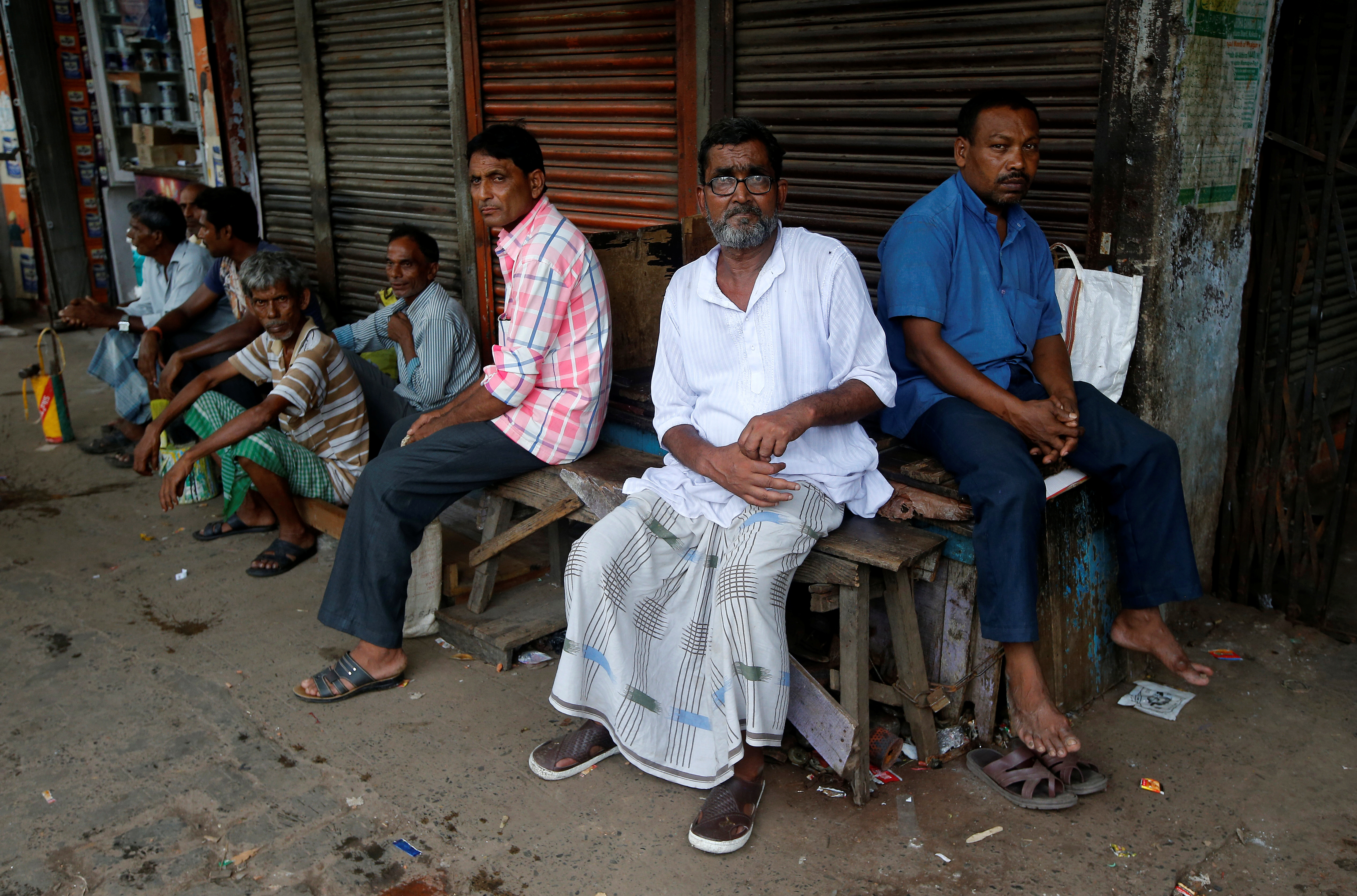 Daily wage workers wait for employment in a market area in Kolkata, India