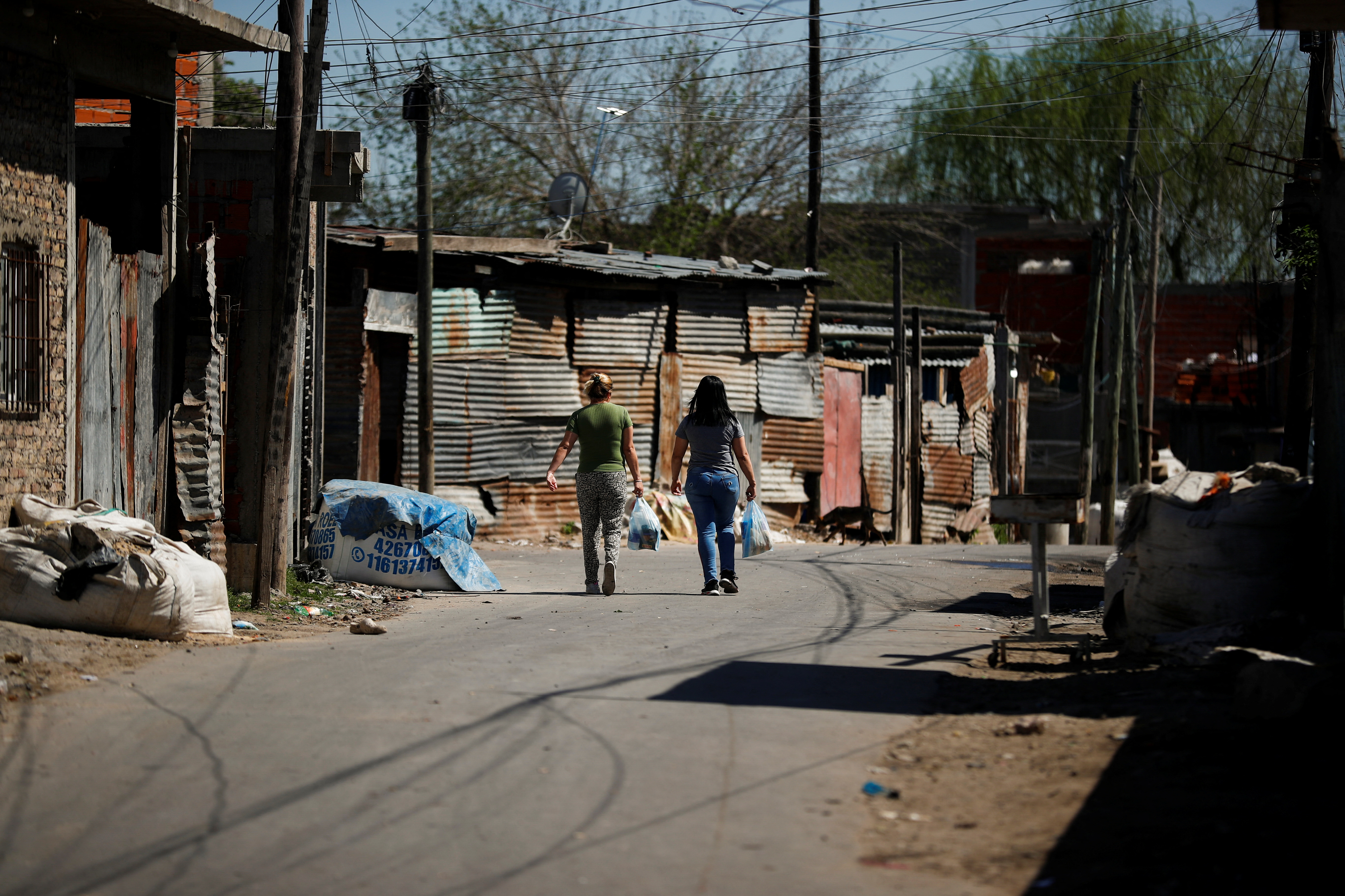 Two women walk down the street in Villa Fiorito