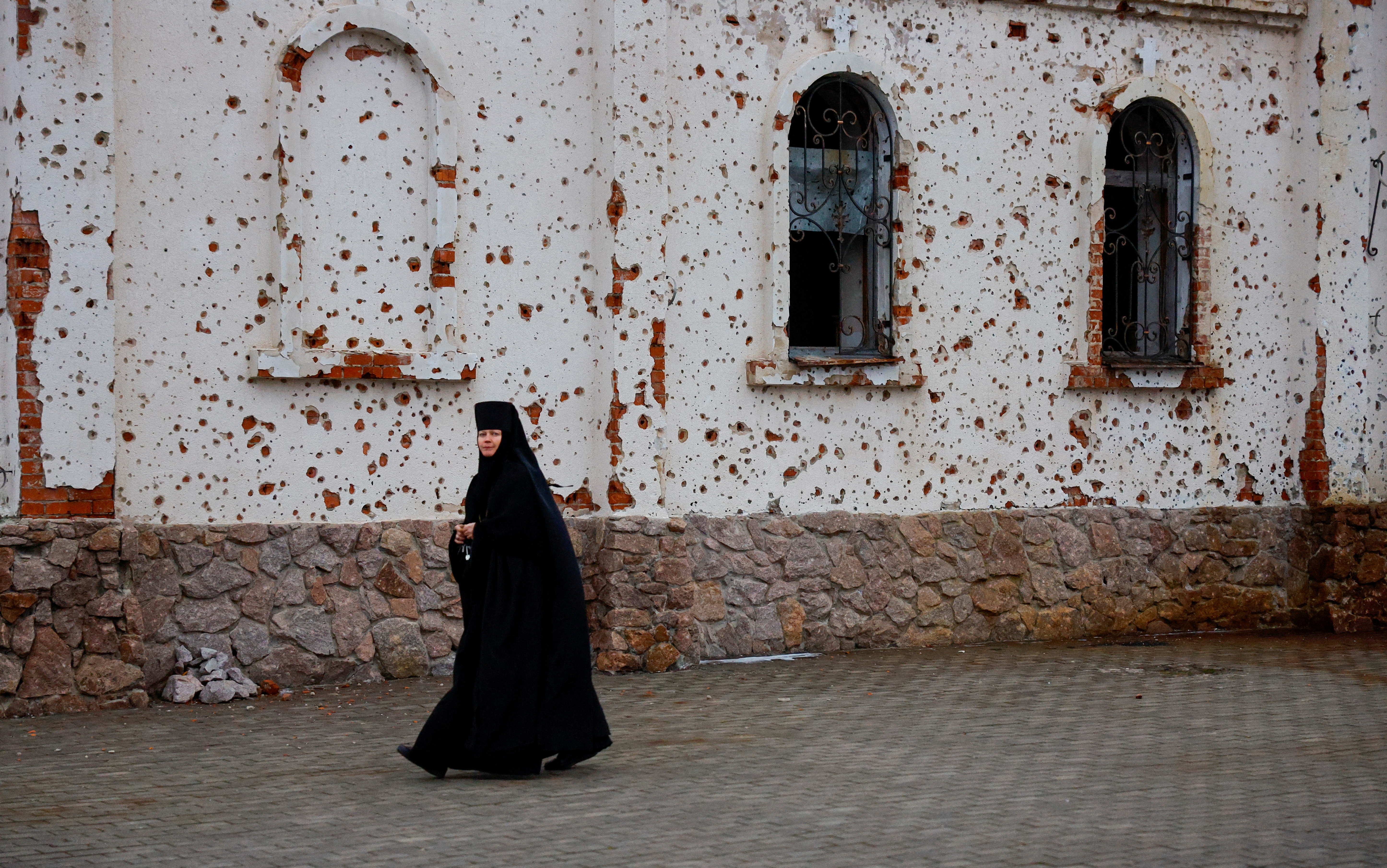 A nun walks outside St. Iveron Monastery, which was heavily damaged by artillery and gun fire during battles for the local airport, as believers attend the Orthodox Christmas service in the course of Russia-Ukraine conflict in Donetsk, Russian-controlled Ukraine, January 7, 2025. REUTERS/Alexander Ermochenko TPX IMAGES OF THE DAY