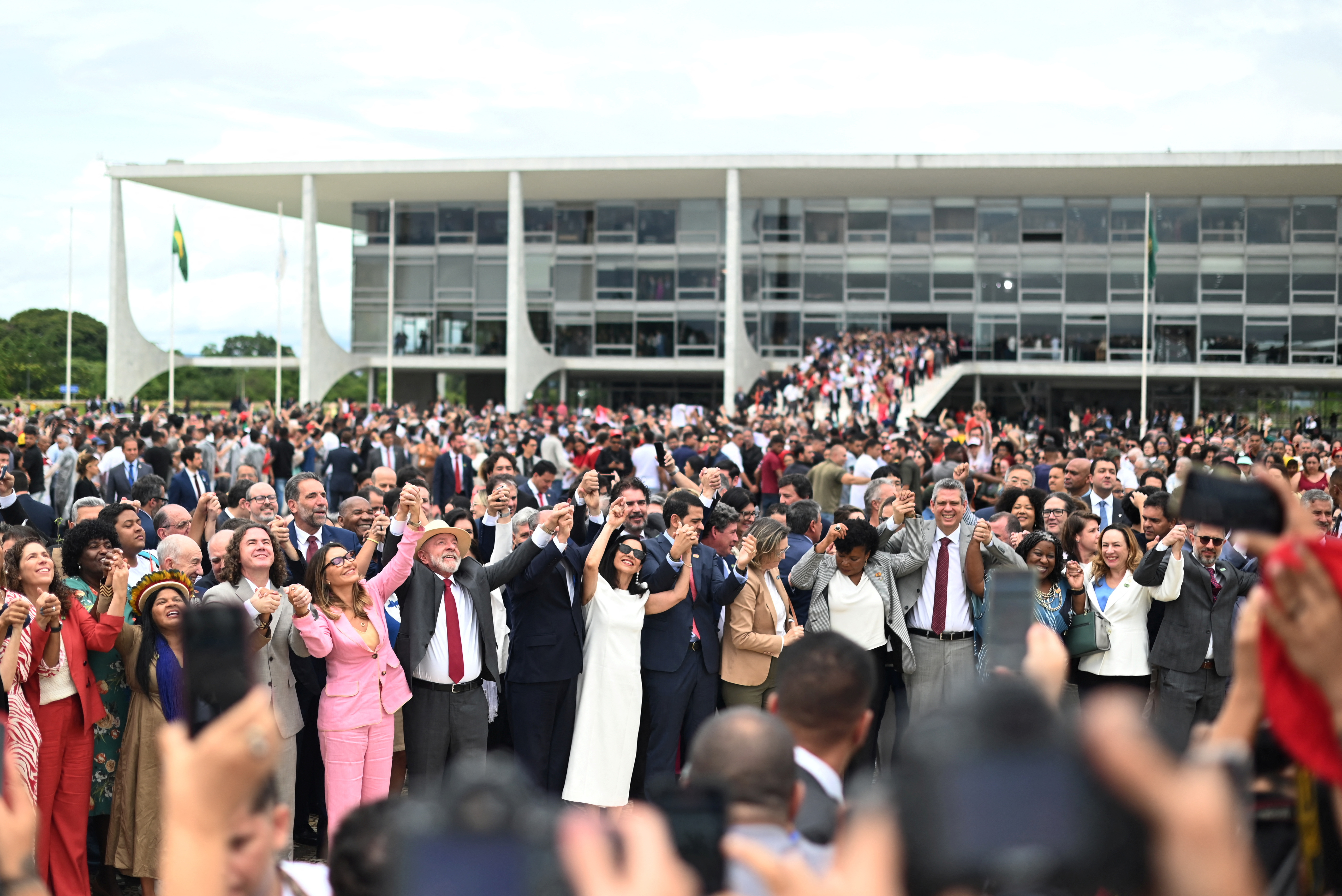 Lula holds hands with officials in the Three Powers Plaza