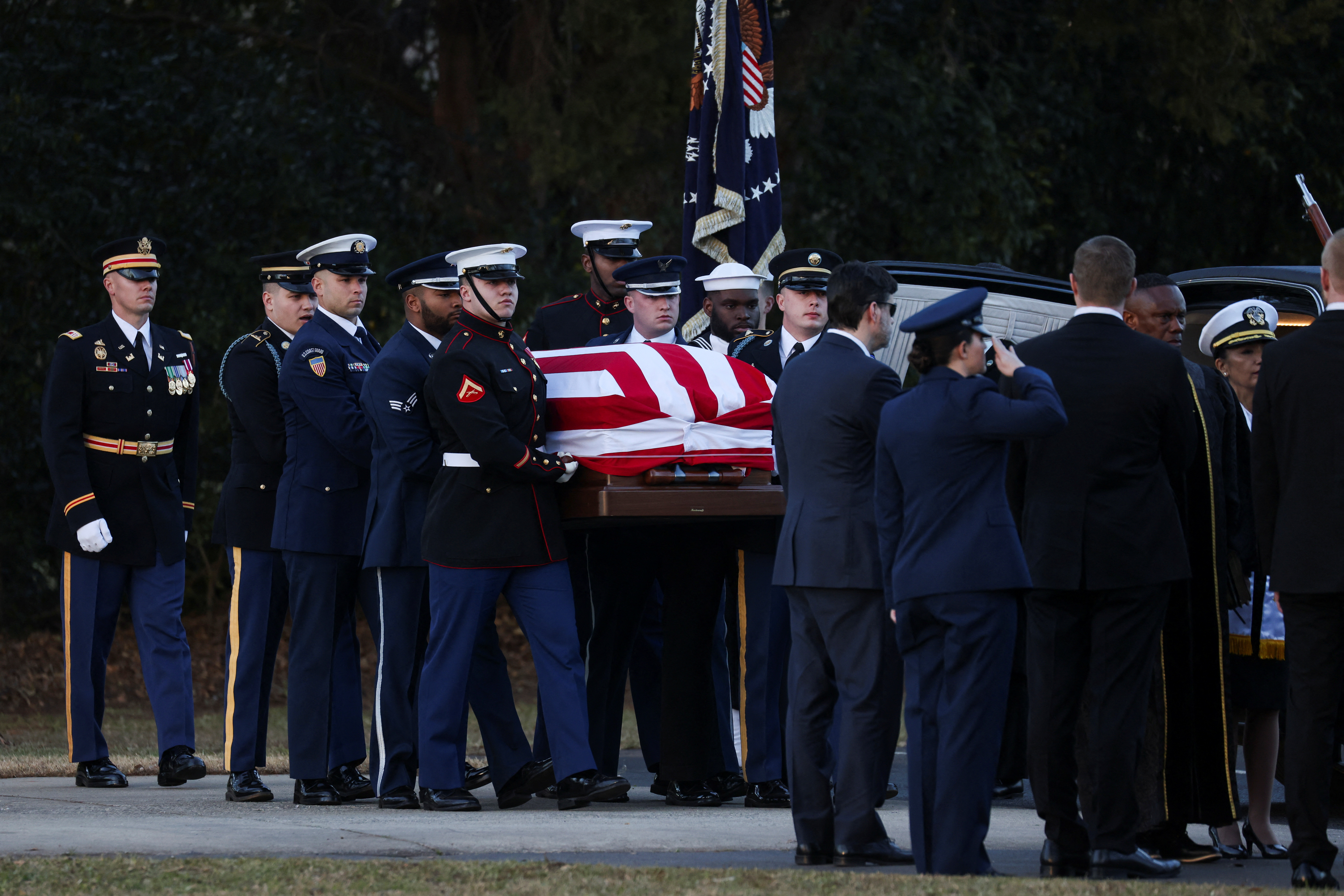 Soldiers carry the flag-draped casket of Jimmy Carter