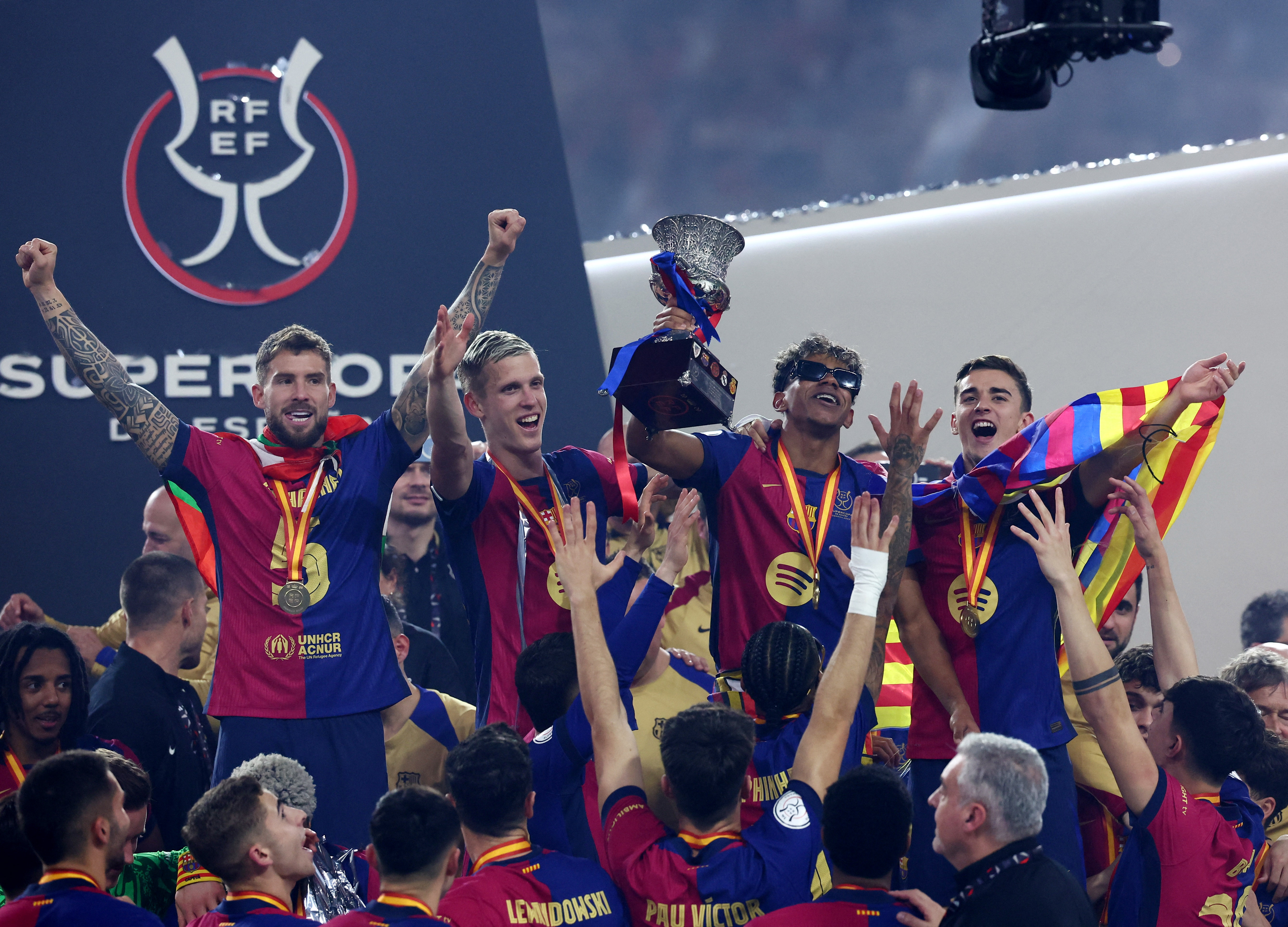 Soccer Football - Spanish Super Cup - Final - FC Barcelona v Real Madrid - King Abdullah Sports City, Jeddah, Saudi Arabia - January 12, 2025 FC Barcelona's Lamine Yamal celebrate with the trophy and teammates after winning the Spanish Super Cup REUTERS/Pedro Nunes