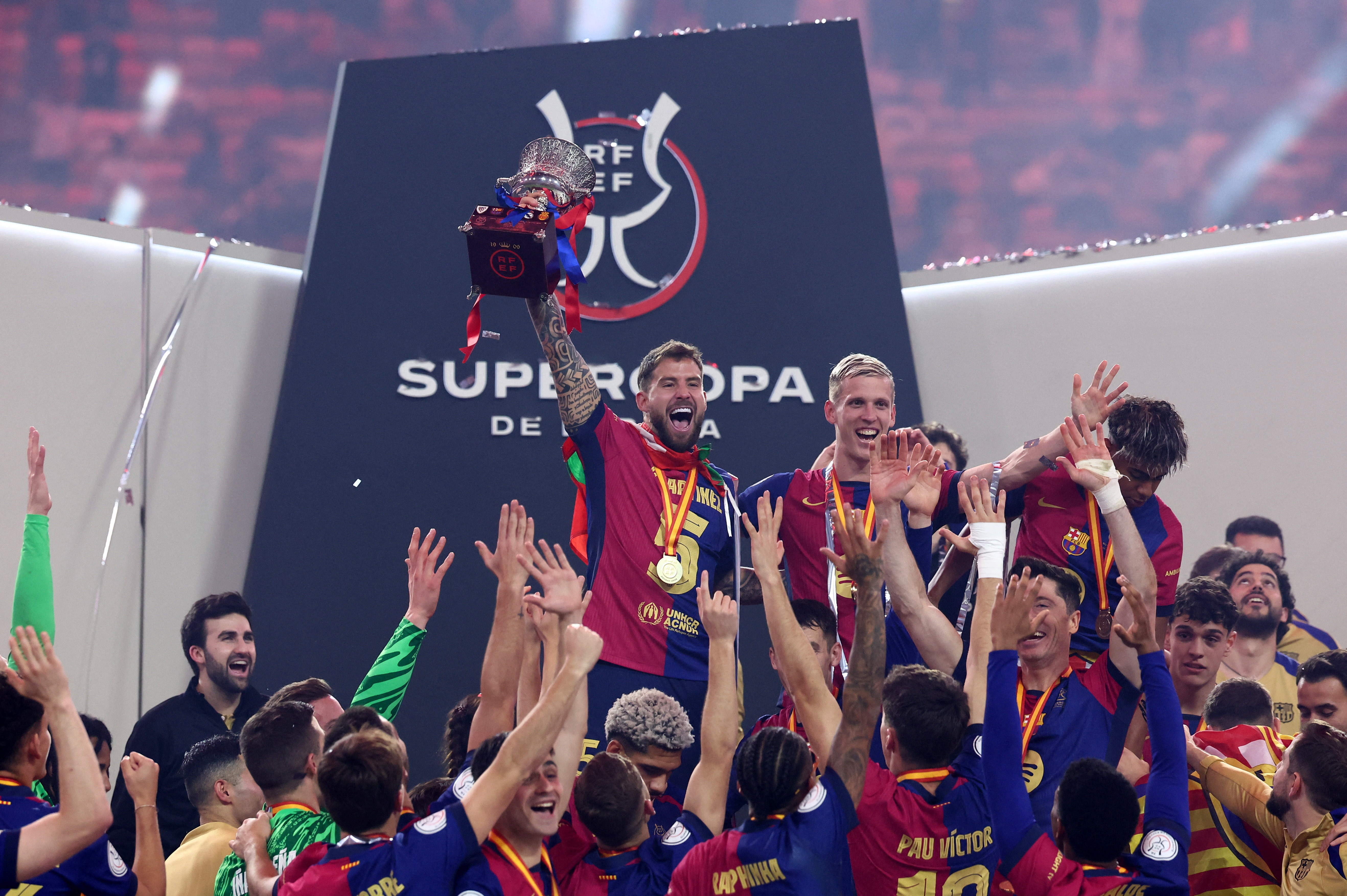 Soccer Football - Spanish Super Cup - Final - FC Barcelona v Real Madrid - King Abdullah Sports City, Jeddah, Saudi Arabia - January 12, 2025 FC Barcelona's Inigo Martinez lifts the trophy as he celebrates winning the Spanish Super Cup with his team mates REUTERS/Pedro Nunes