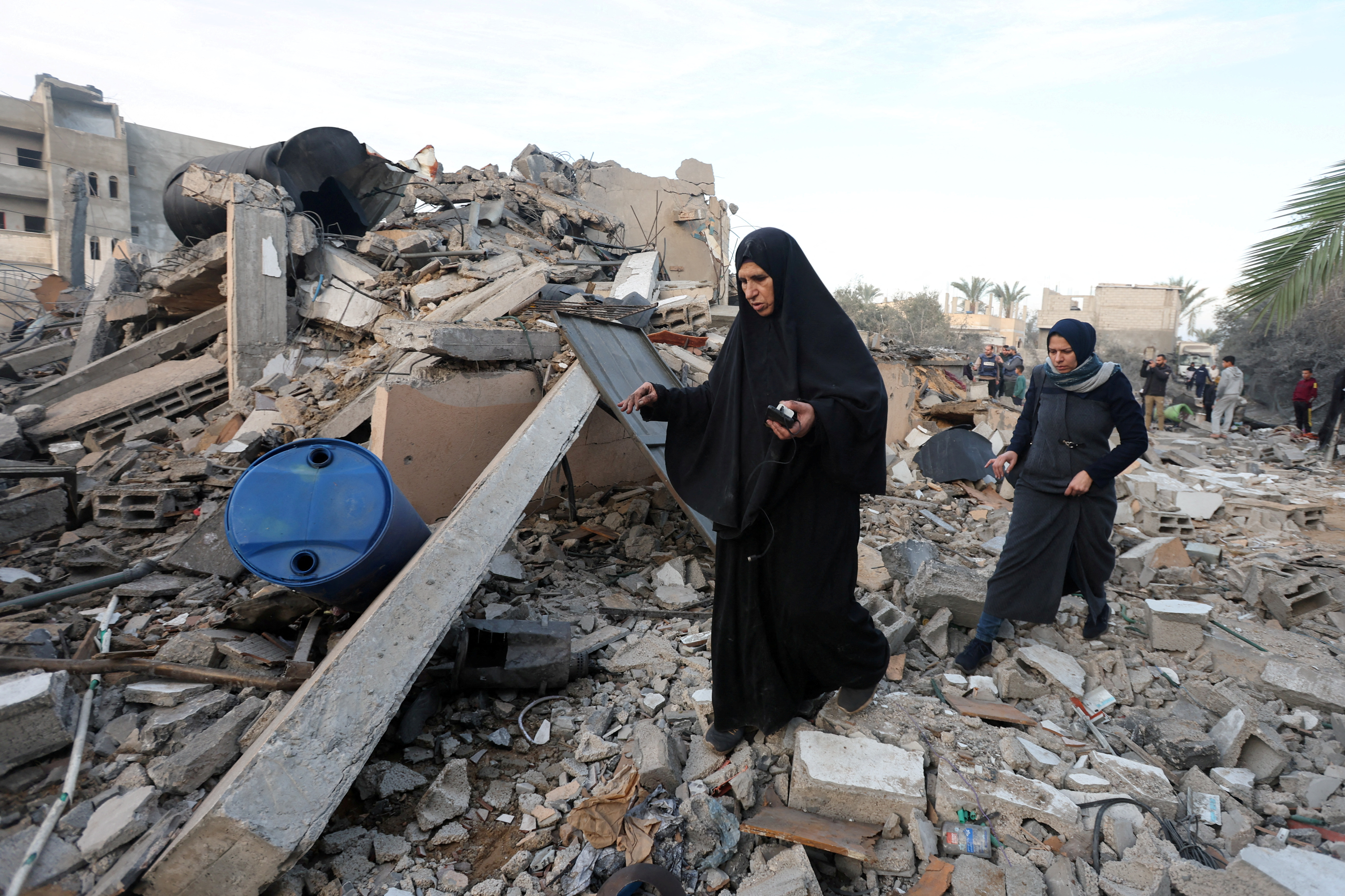 Palestinians inspect the site of an Israeli strike on a house, amid the ongoing conflict between Israel and Hamas, in Deir Al-Balah in the central Gaza Strip, January 15, 2025. REUTERS/Ramadan Abed