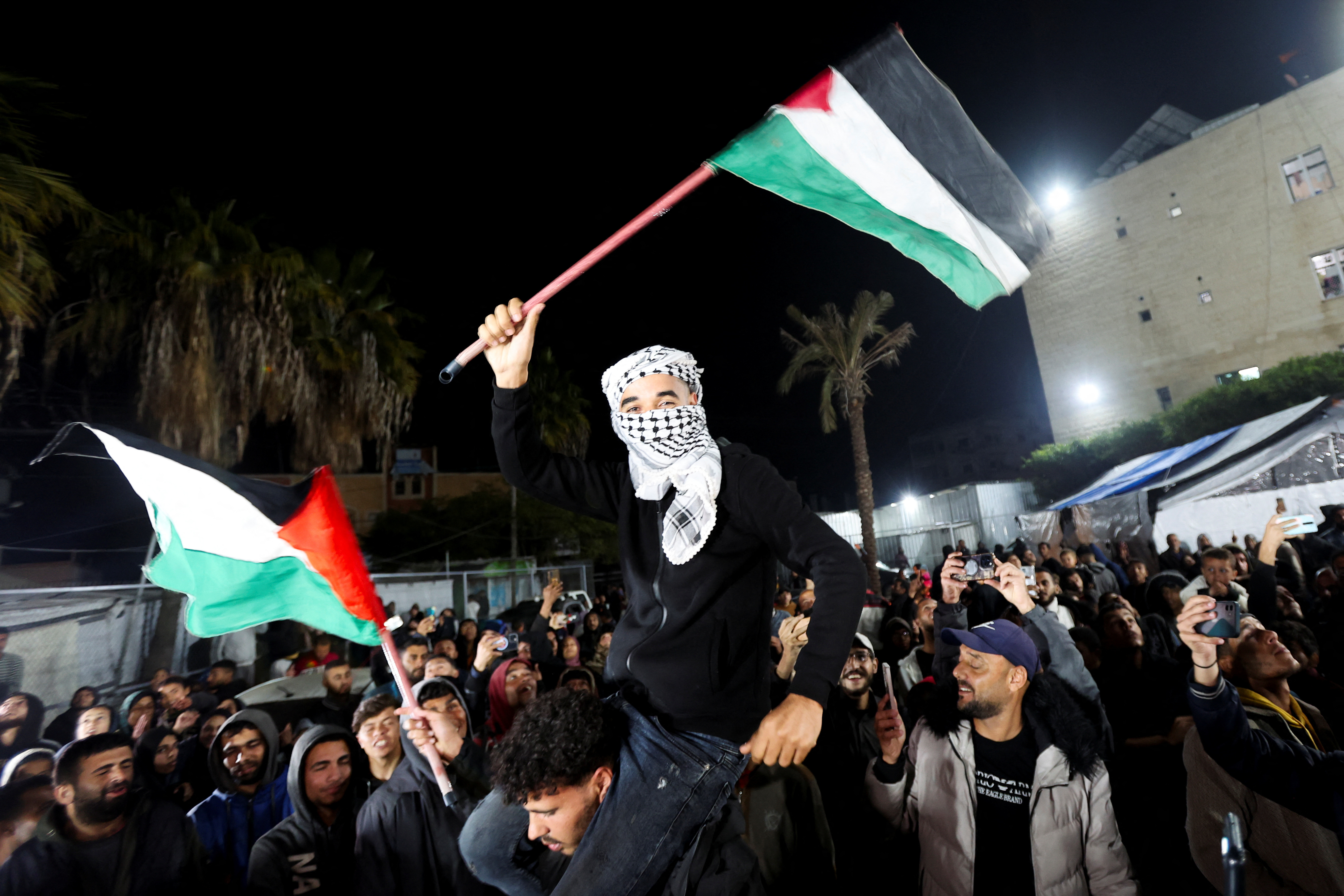 Palestinians react as they wait for news of a ceasefire deal with Israel