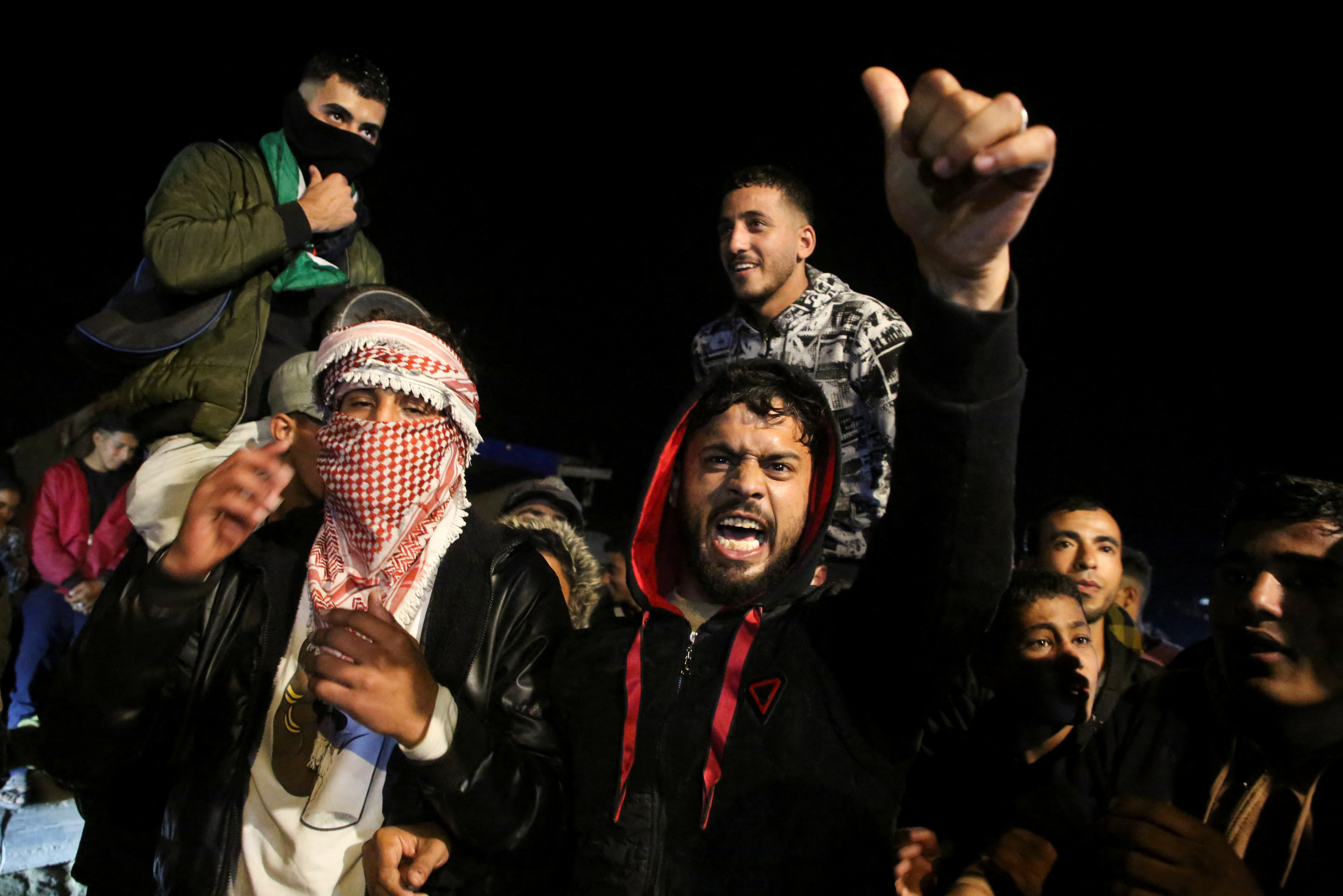 Palestinians react as they wait for news of a ceasefire deal with Israel