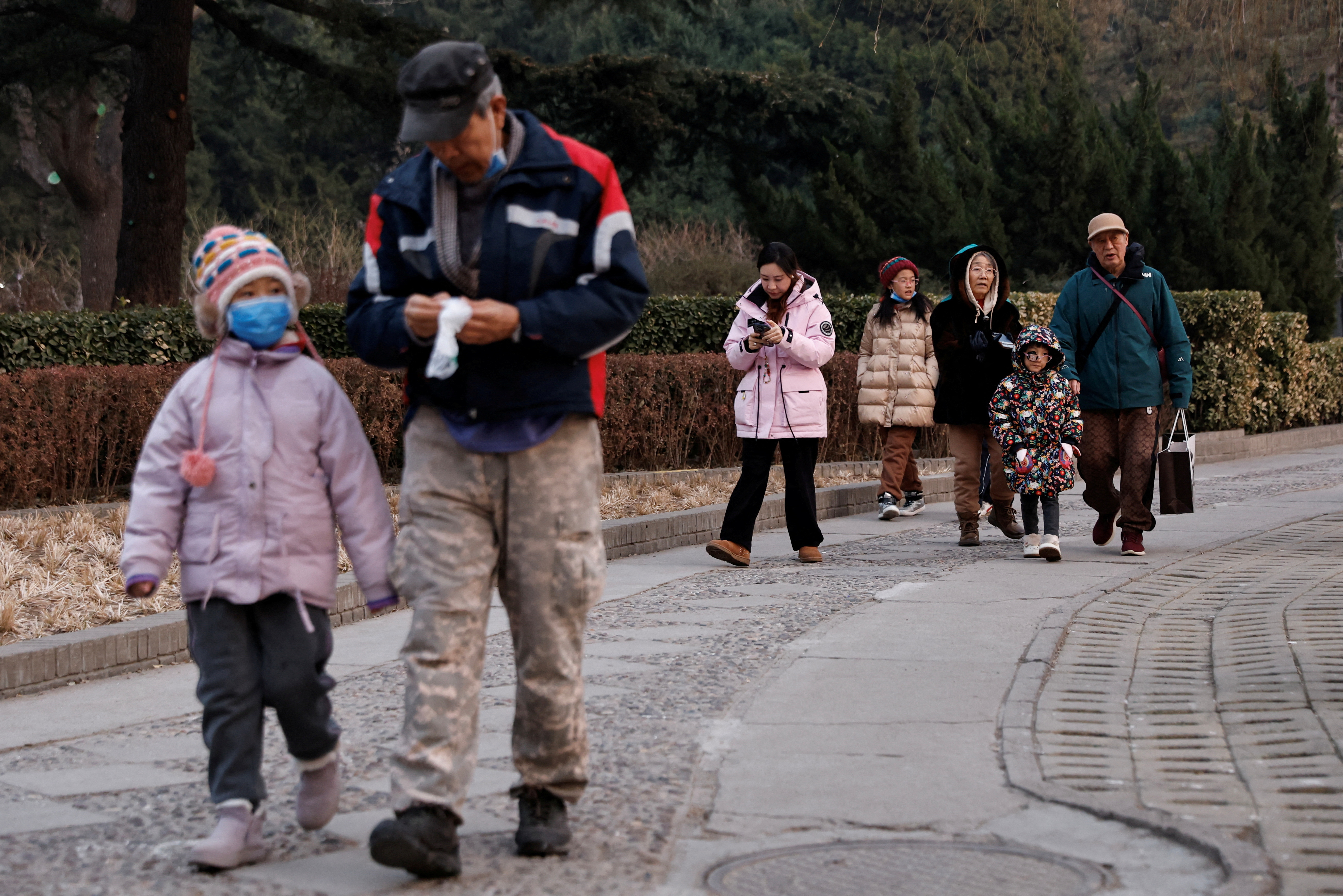 FILE PHOTO: Elderly people walk with children at a park in Beijing, China January 12, 2024. REUTERS/Tingshu Wang/File Photo