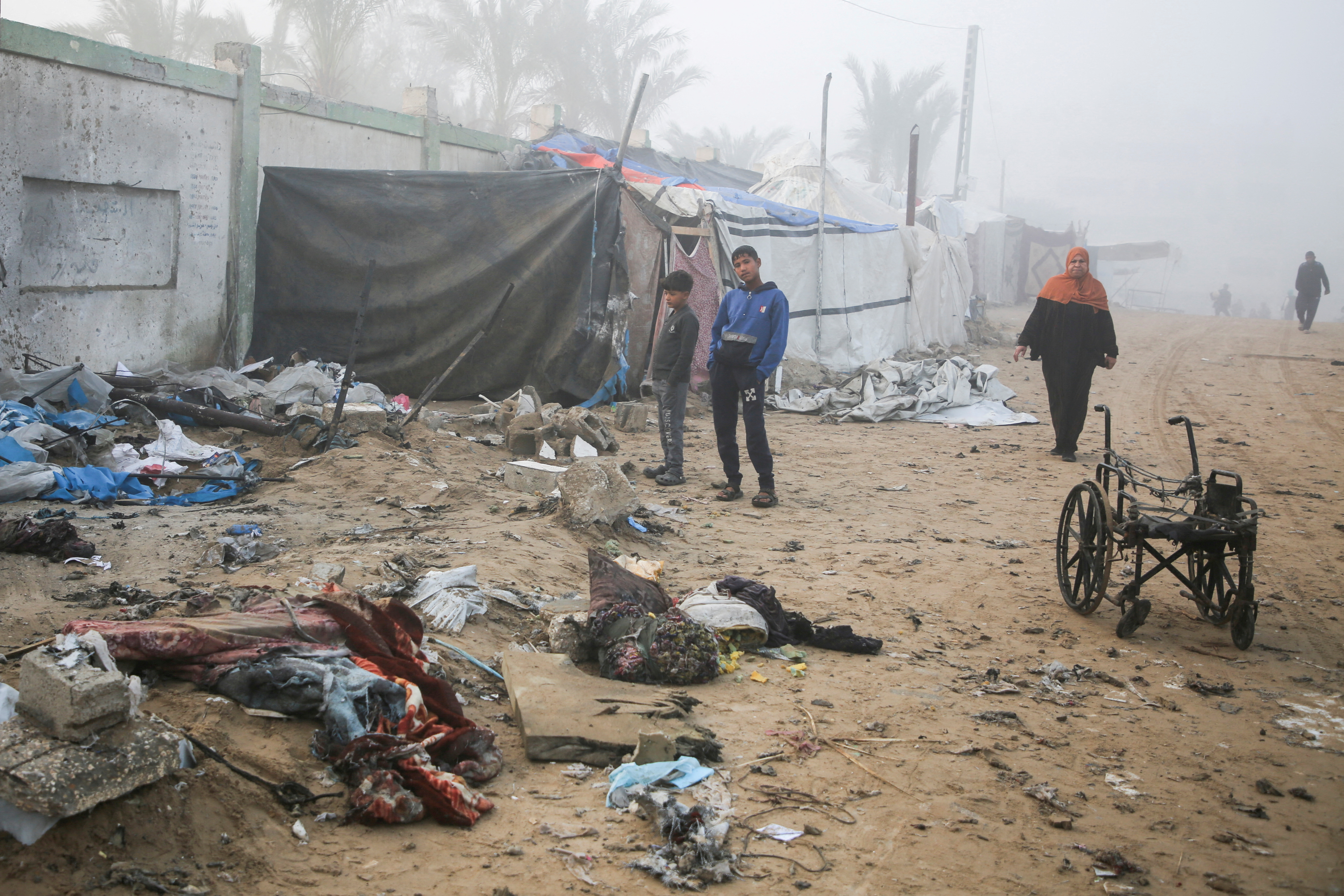 Palestinian boys stand near a damaged tent for displaced people, after an Israeli airstrike in Khan Younis, southern Gaza Strip, January 17, 2025. [Hatem Khaled/Reuters]