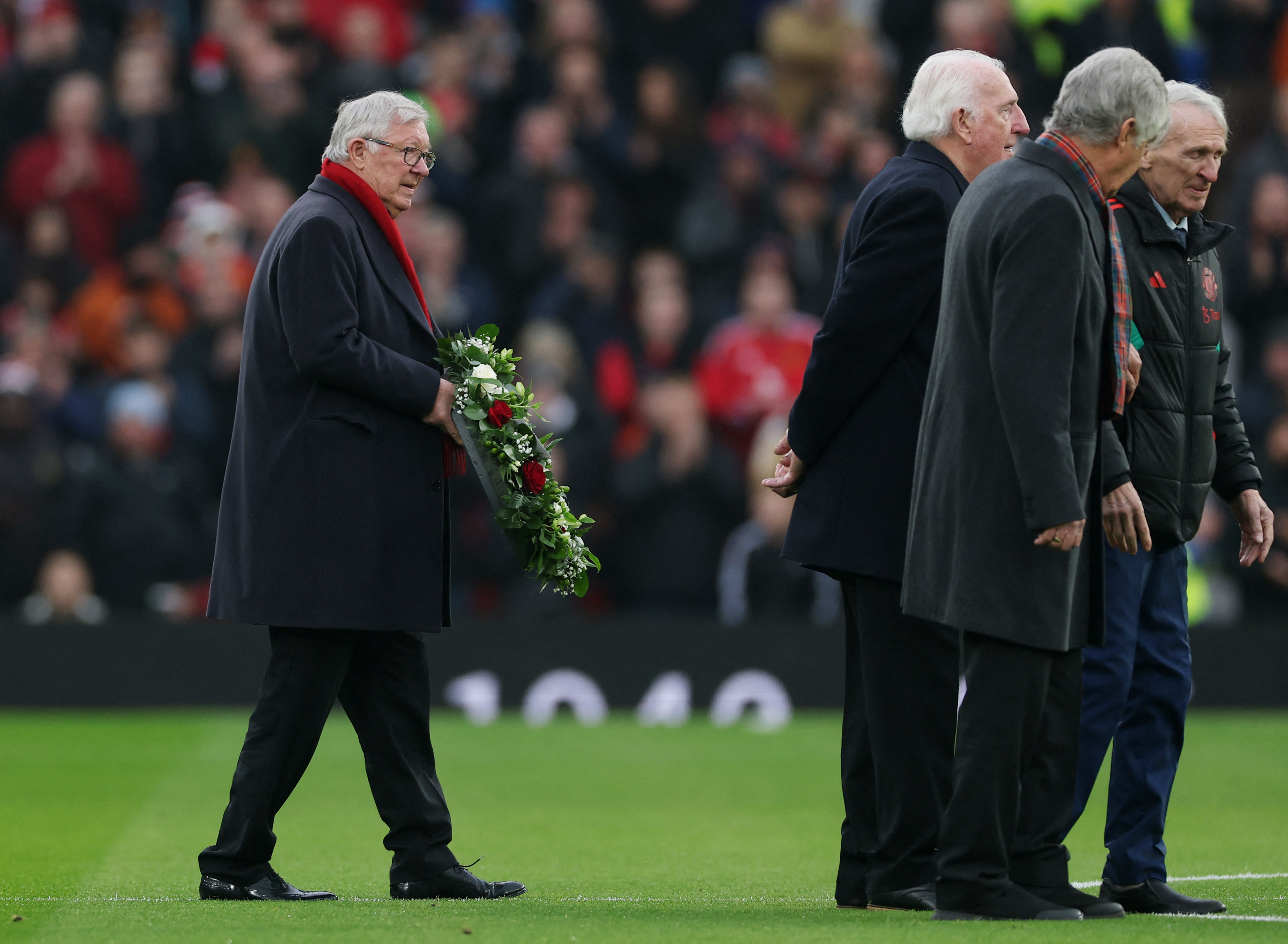 Soccer Football - Premier League - Manchester United v Brighton & Hove Albion - Old Trafford, Manchester, Britain - January 19, 2025 Former Manchester United manager Alex Ferguson holds a wreath in memory of former Manchester United player Denis Law Action Images via Reuters/Lee Smith EDITORIAL USE ONLY. NO USE WITH UNAUTHORIZED AUDIO, VIDEO, DATA, FIXTURE LISTS, CLUB/LEAGUE LOGOS OR 'LIVE' SERVICES. ONLINE IN-MATCH USE LIMITED TO 120 IMAGES, NO VIDEO EMULATION. NO USE IN BETTING, GAMES OR SINGLE CLUB/LEAGUE/PLAYER PUBLICATIONS. PLEASE CONTACT YOUR ACCOUNT REPRESENTATIVE FOR FURTHER DETAILS..