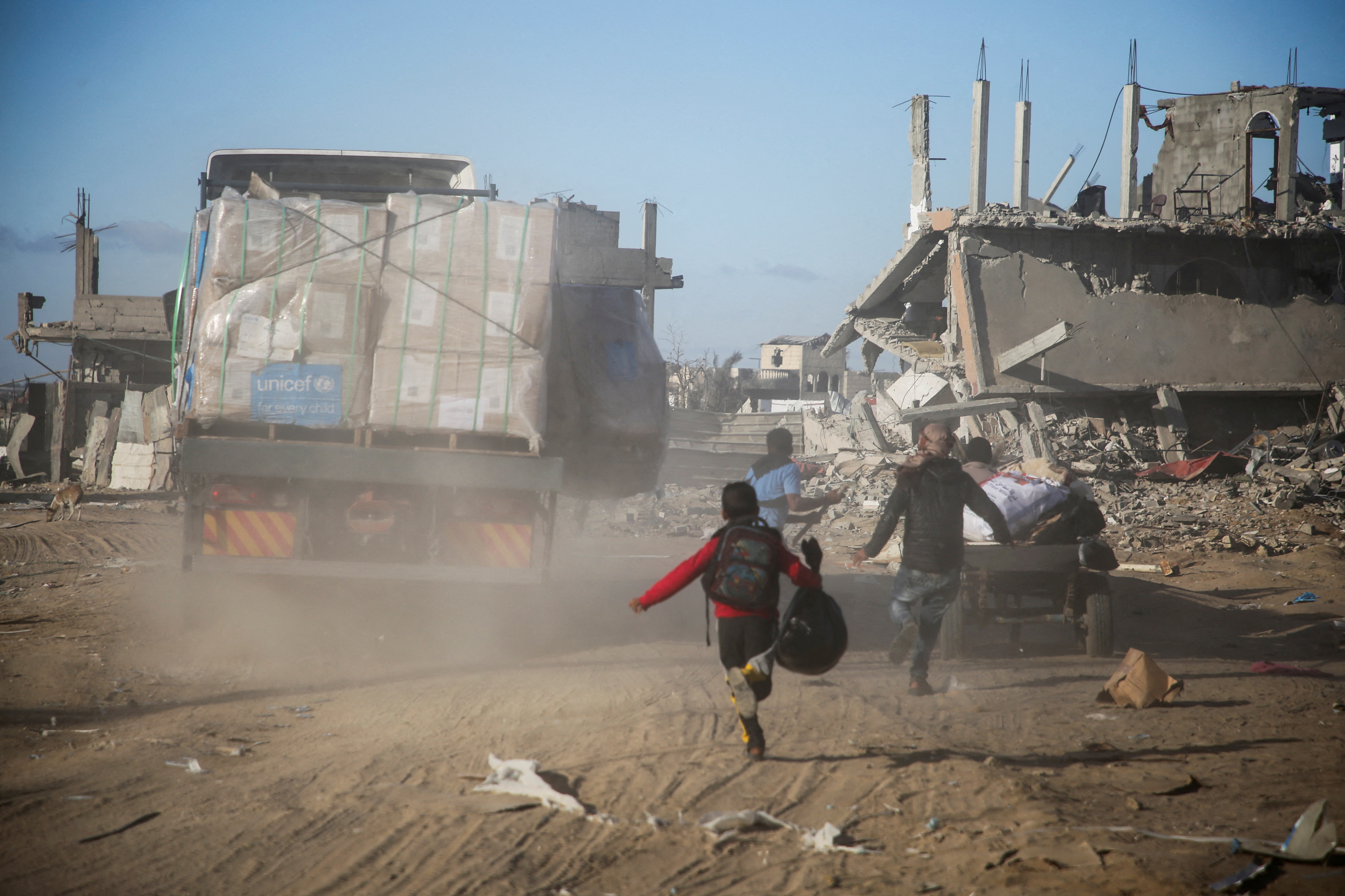 Palestinians run towards aid trucks, following a ceasefire between Israel and Hamas, in Rafah in the southern Gaza Strip, January 20, 2025 [Hatem Khaled/Reuters]