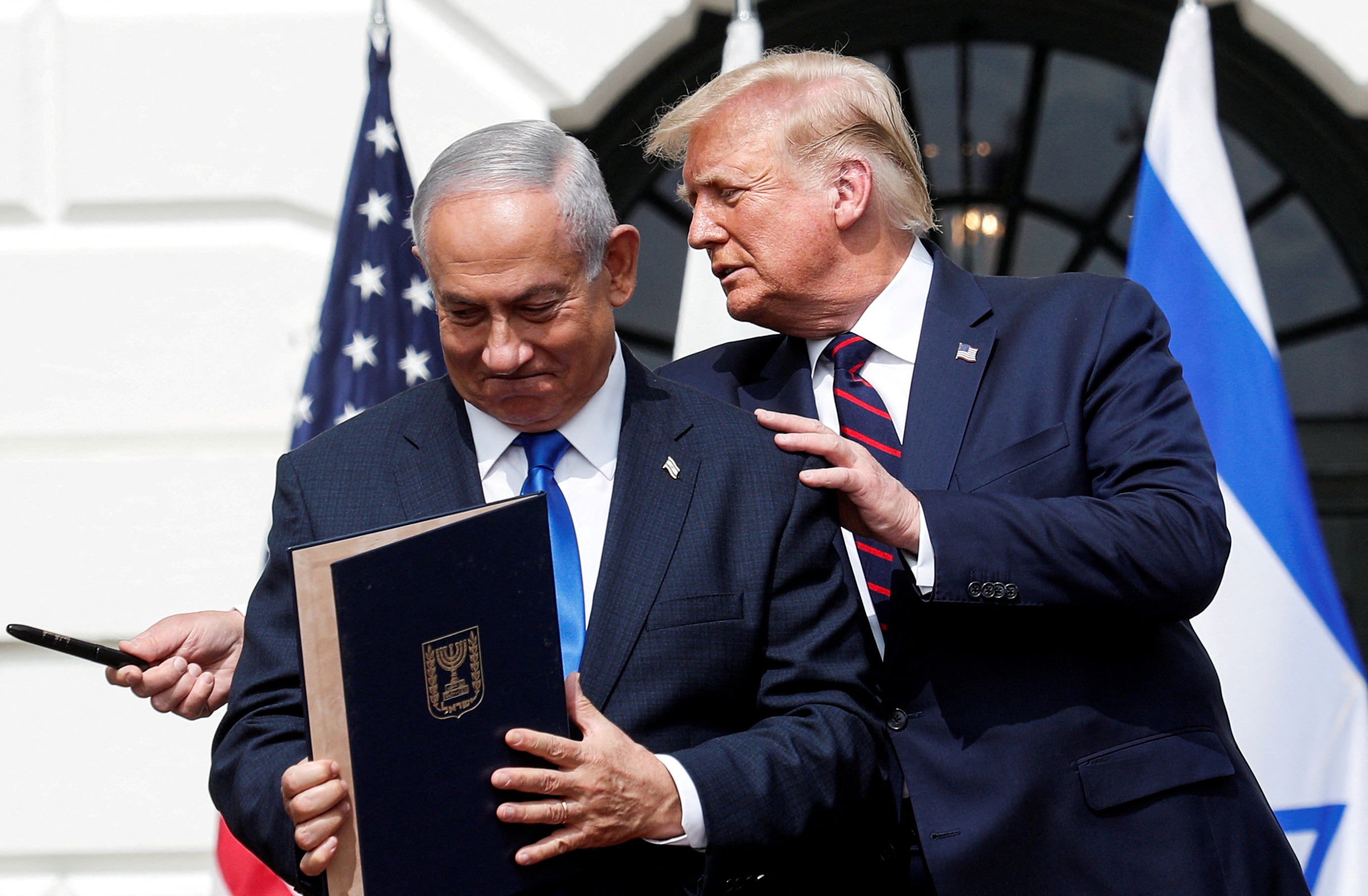 FILE PHOTO: Israel's Prime Minister Benjamin Netanyahu stands with U.S. President Donald Trump after signing the Abraham Accords, normalizing relations between Israel and some of its Middle East neighbors, in a strategic realignment of Middle Eastern countries against Iran, on the South Lawn of the White House in Washington, U.S., September 15, 2020. REUTERS/Tom Brenner/File Photo