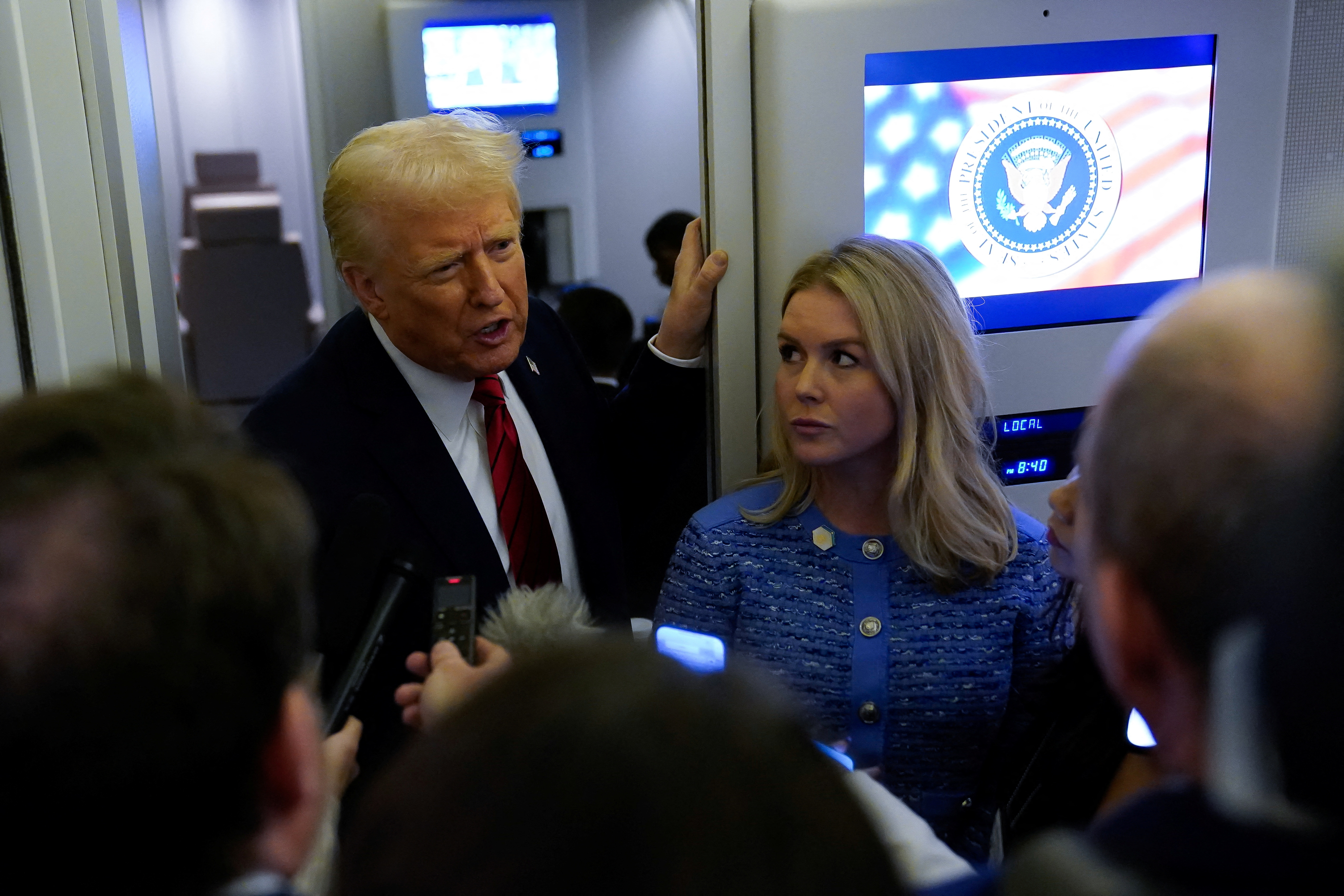 U.S. President Donald Trump speaks to reporters with White House Press Secretary Karoline Leavitt aboard Air Force One before arriving at Joint Base Andrews, Maryland, U.S., January 27, 2025. REUTERS/Elizabeth Frantz