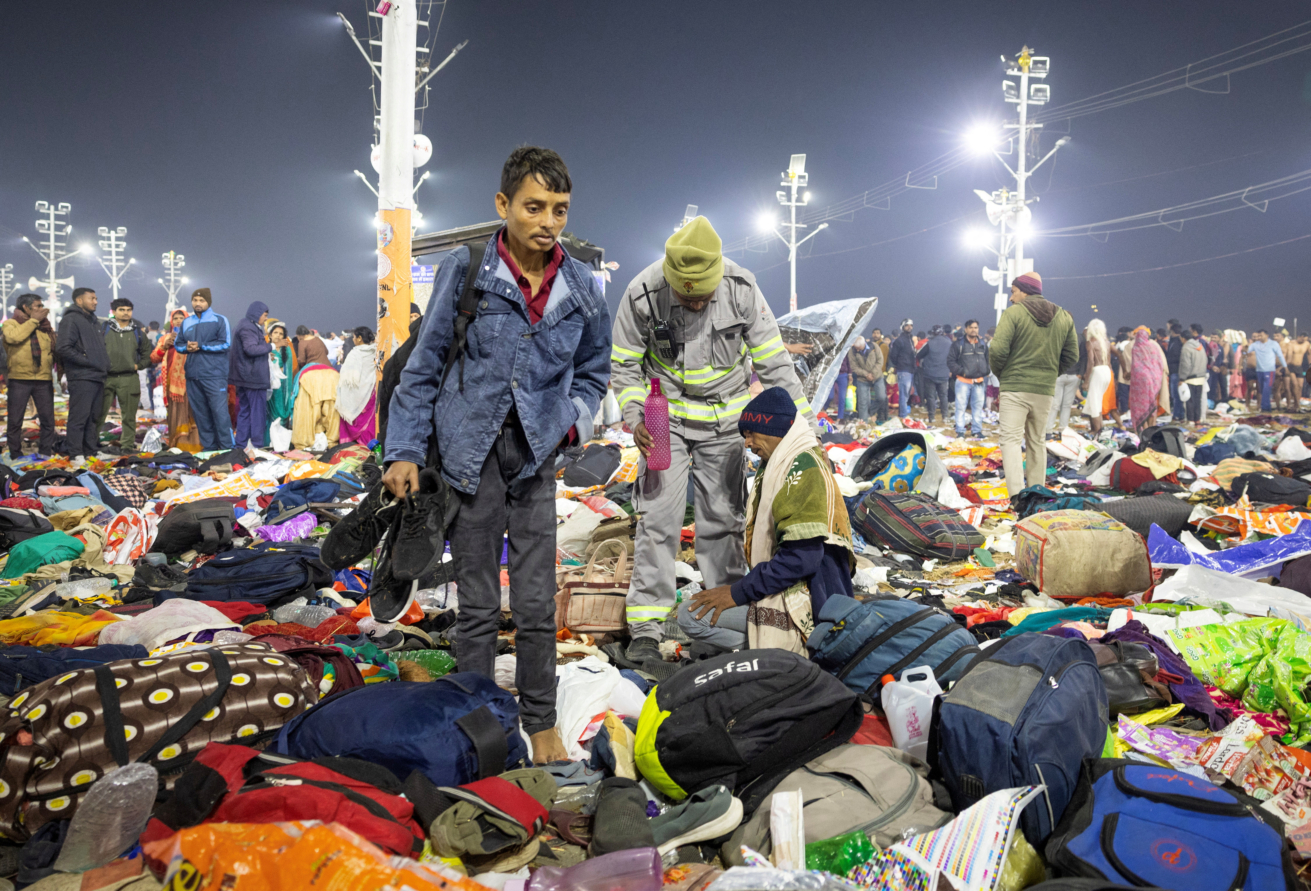 A policeman helps an injured after a stampede before the second "Shahi Snan" (royal bath)