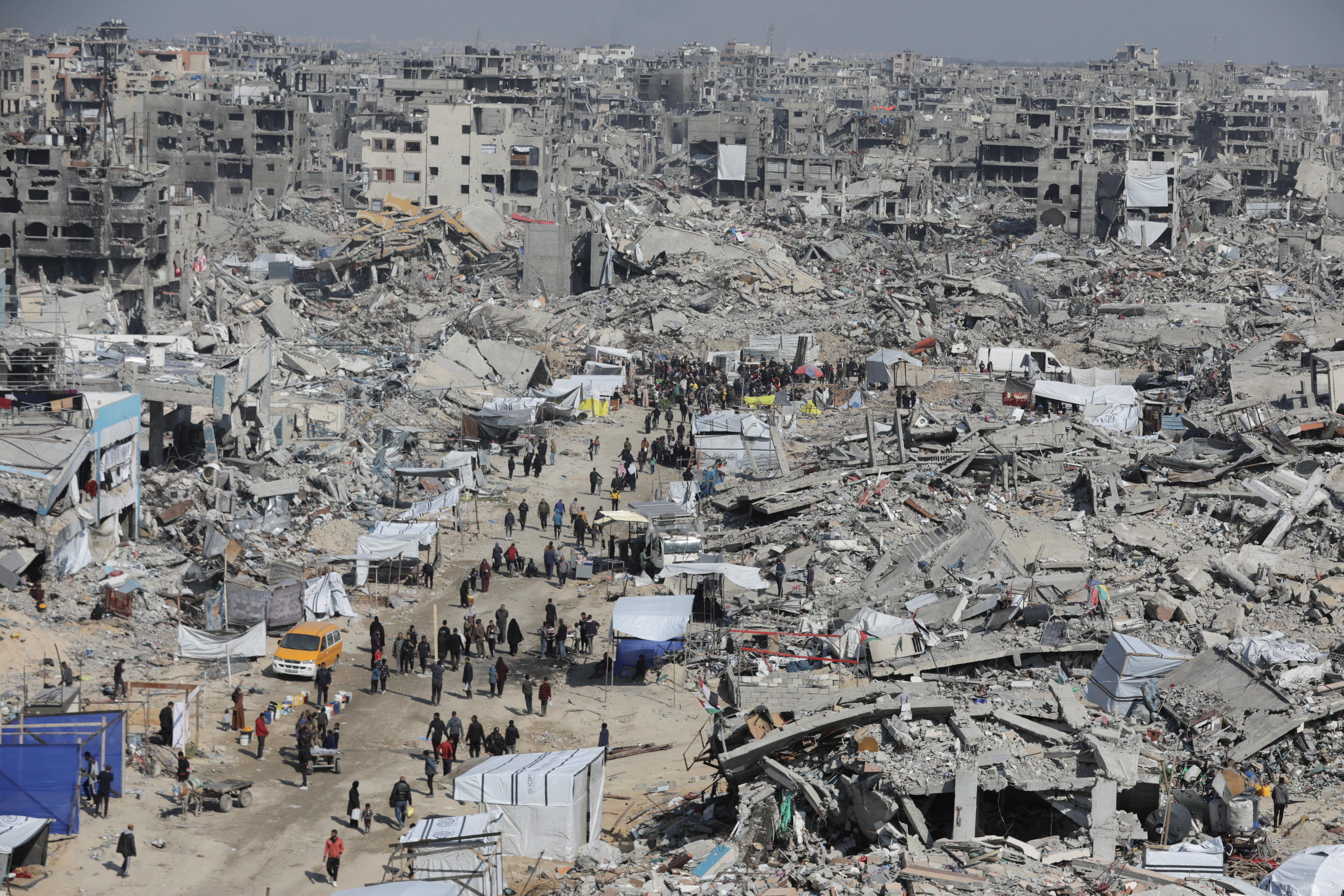 Palestinians walk through the rubble of houses and buildings destroyed during the Israeli offensive, amid a ceasefire between Israel and Hamas, in Jabalia refugee camp in the northern Gaza Strip January 29, 2025. REUTERS/Mahmoud Issa