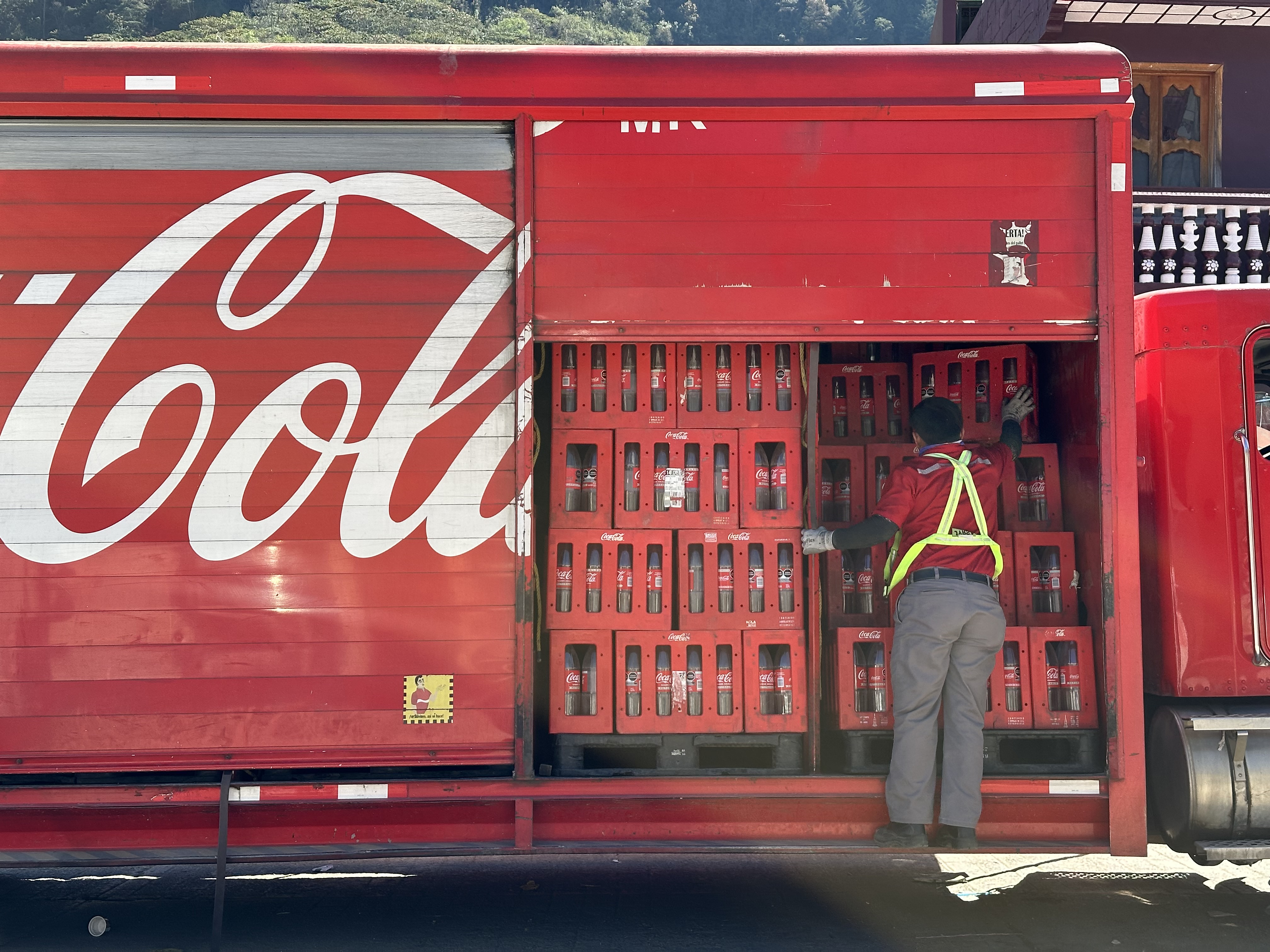A truck driver delivers crates of Coca-Cola