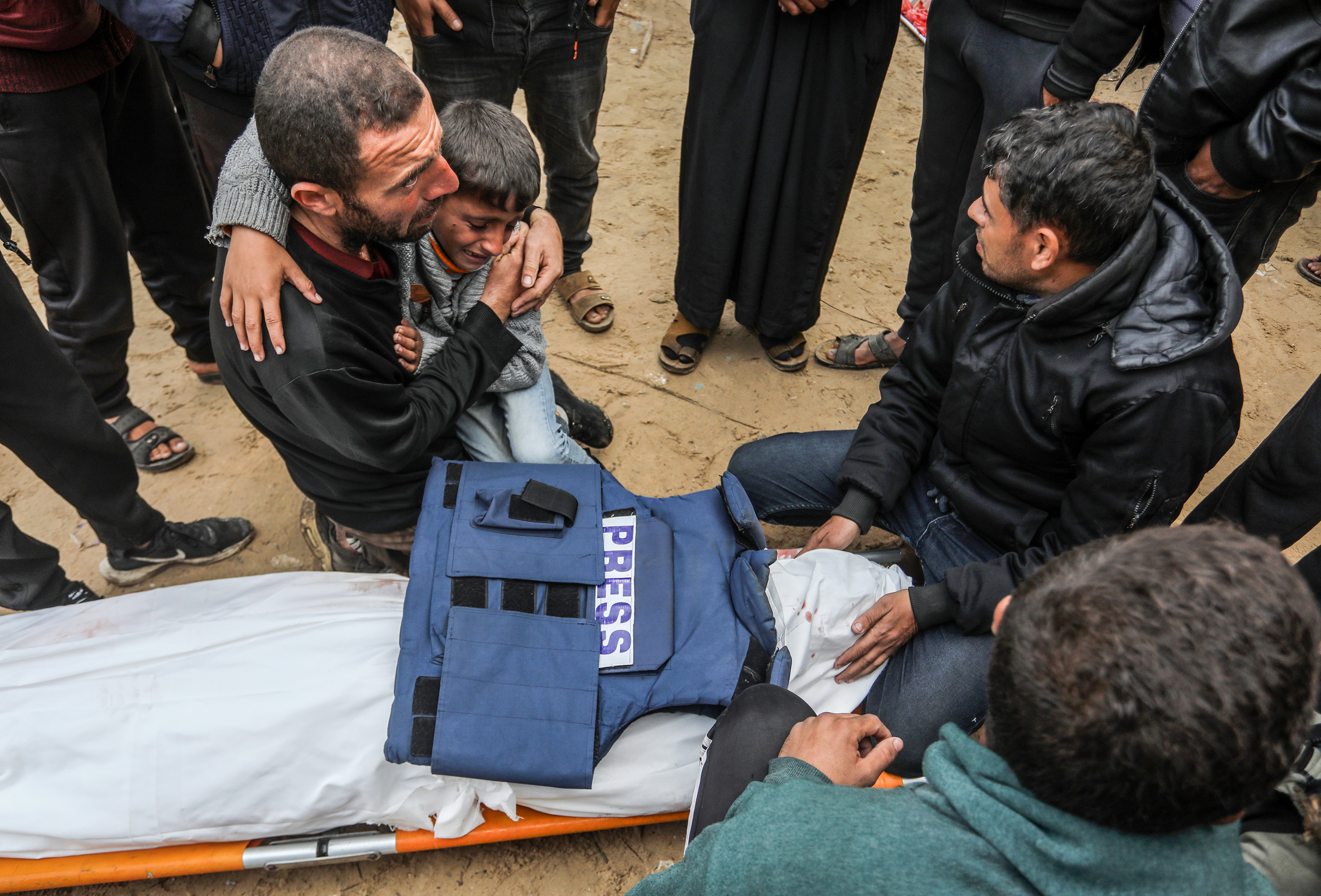 KHAN YUNIS, GAZA - JANUARY 16: Relatives of Ahmad Al-Shayah, a journalist killed in Israeli drone attack on a charity facility, mourn by his shrouded body at Nasser Hospital in Khan Yunis, Gaza on January 16, 2025. ( Abed Rahim Khatib - Anadolu Agency )