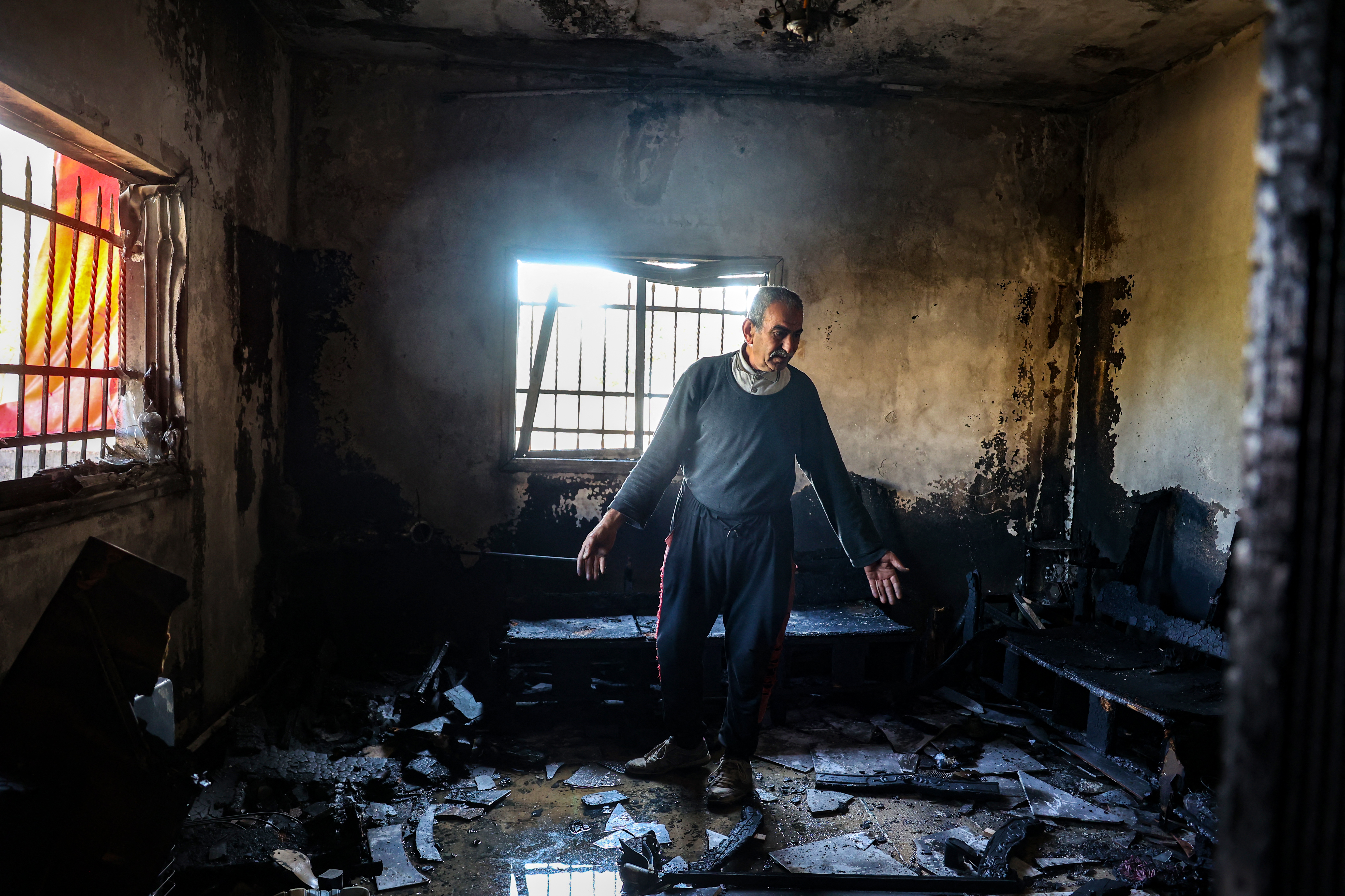 A Palestinian man inspects the damage in his house in Huwara south of Nablus, in the occupied West Bank, following a reported attack by Israeli settlers early on December 4, 2024. (Photo by Zain JAAFAR / AFP)
