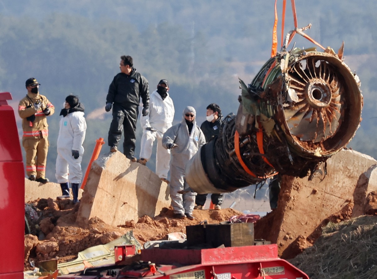 Teams salvage an engine of the Jeju Air Boeing 737-800 aircraft which crashed and burst into flames at Muan International Airport, in Muan on January 3, 2025. Jeju Air flight 2216 was carrying 181 people from Thailand to South Korea on December 29, 2024, when it issued a mayday call and belly-landed before hitting a barrier and bursting into flames, killing everyone aboard except two flight attendants pulled from the burning wreckage. (Photo by YONHAP / AFP) / NO USE AFTER JANUARY 13, 2025 07:14:08 GMT - SOUTH KOREA OUT / NO ARCHIVES - RESTRICTED TO SUBSCRIPTION USE NO USE AFTER JANUARY 13, 2025 07:14:08 GMT - SOUTH KOREA OUT