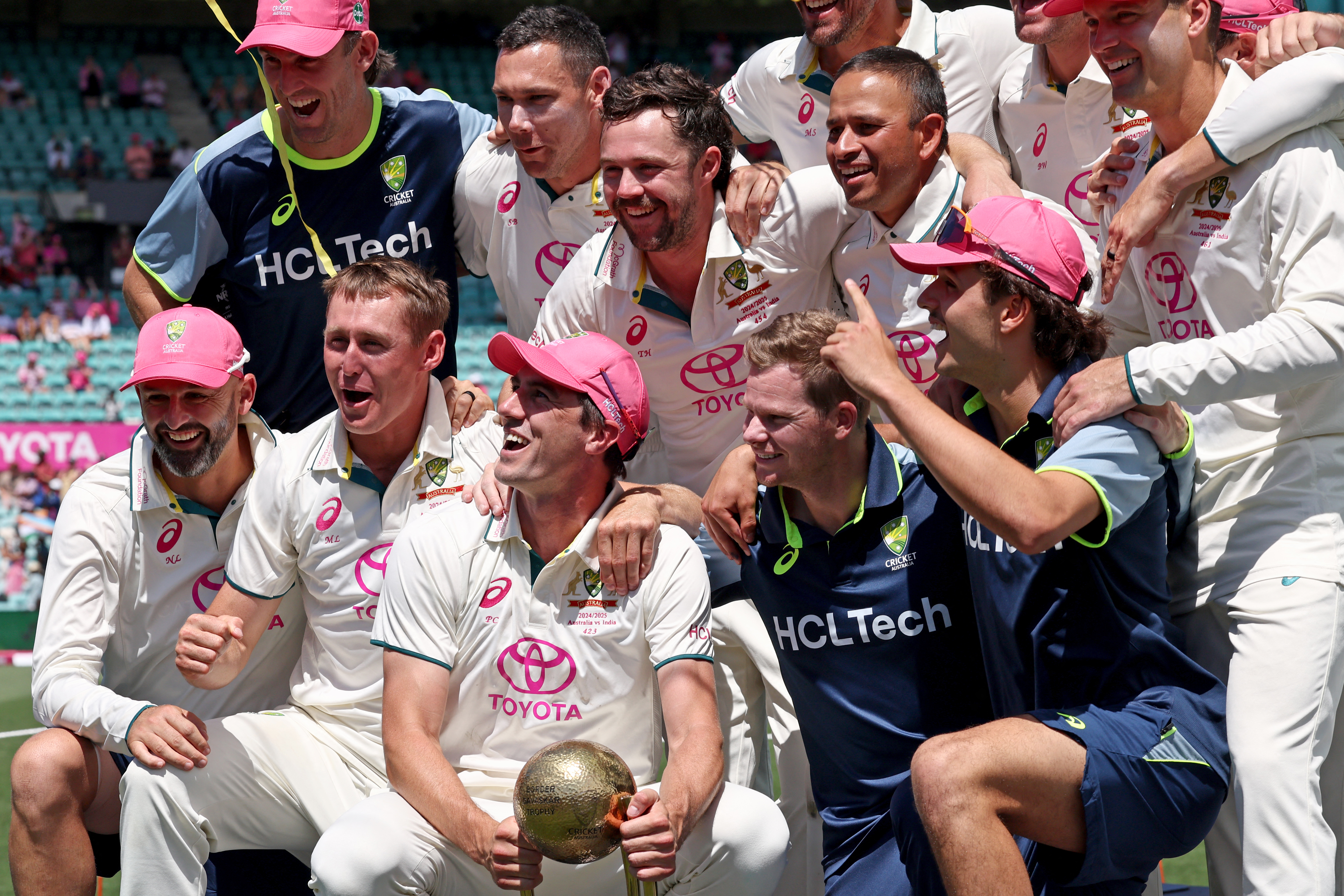 Australian captain Pat Cummins (C) poses with the trophy and teammates for a photo after winning.