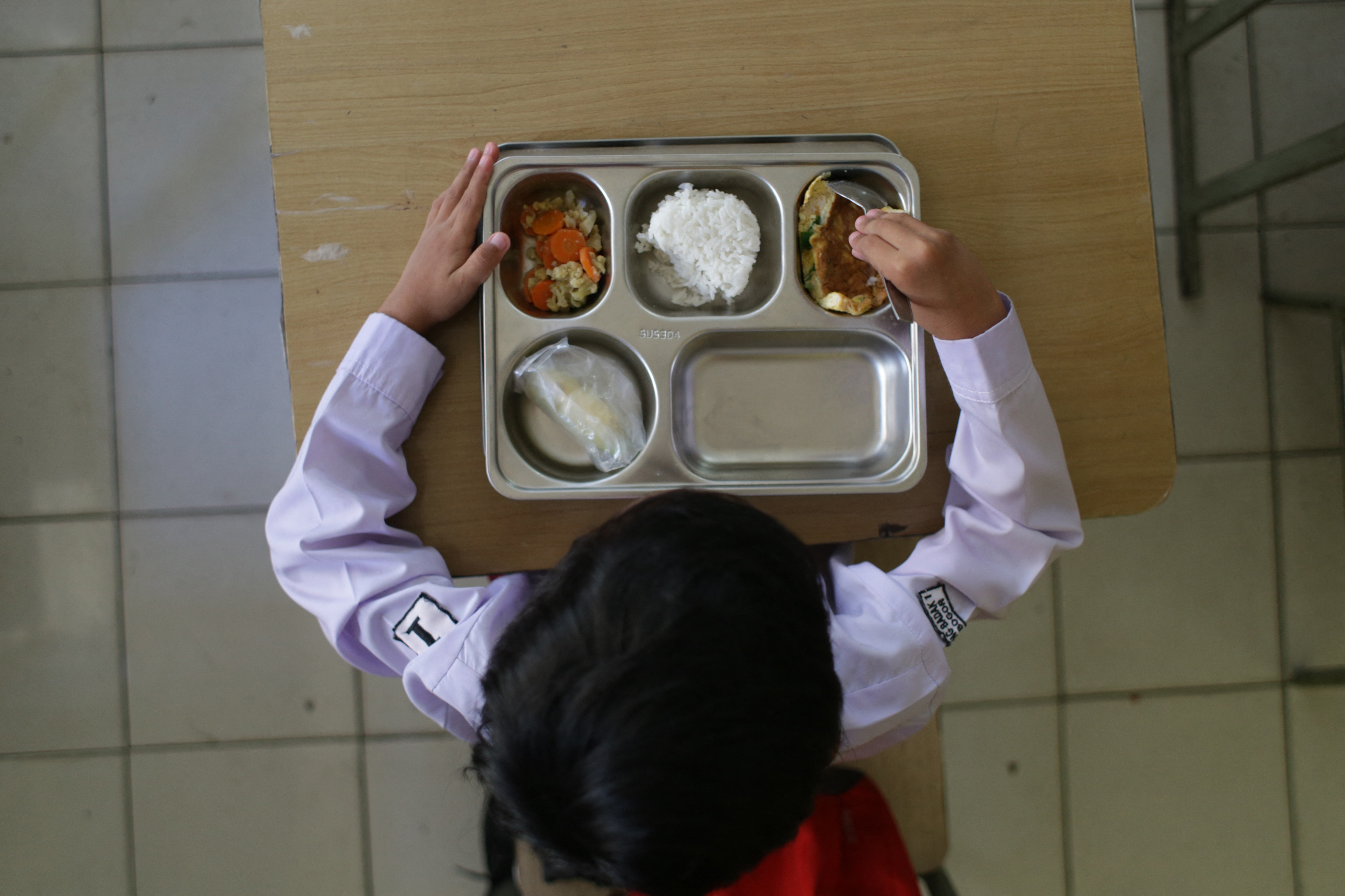 A student eats lunch on the first day of a free-meal programme at Kedung Badag 1 State Elementary School in Bogor, West Java, on January 6