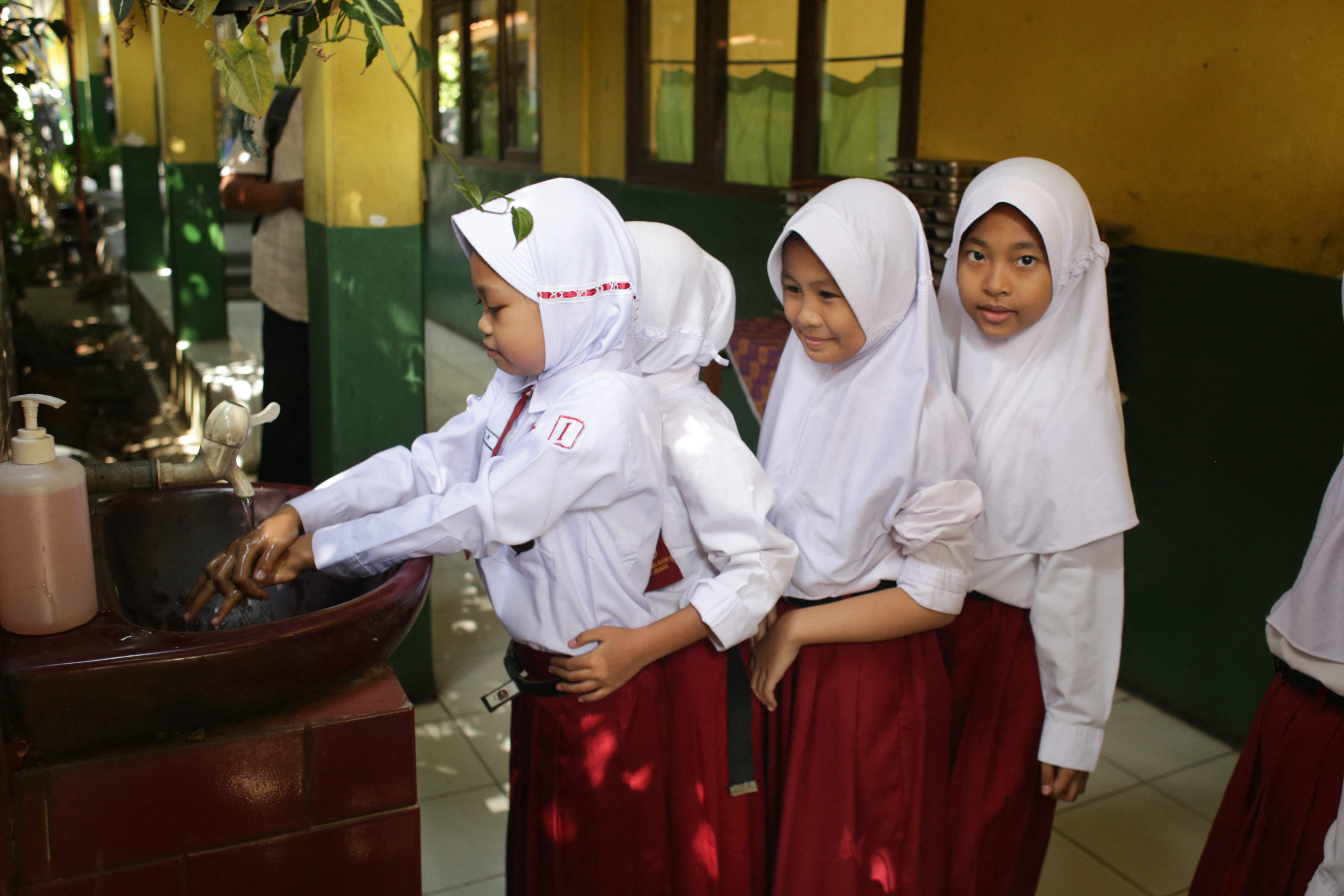 Students wash their hands before having lunch on the first day of a free-meal programme at Kedung Badag 1 State Elementary School in Bogor, West Java, on January 6