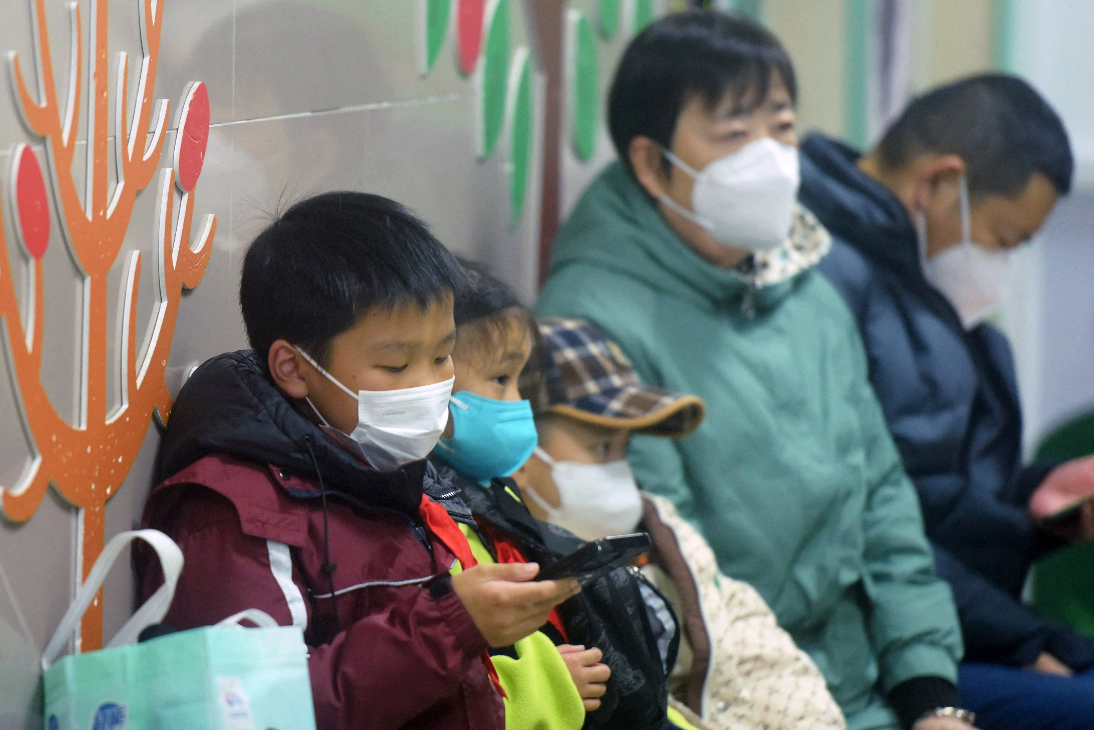 Masked children wait to be seen by medical staff at a hospital in Hangzhou, China