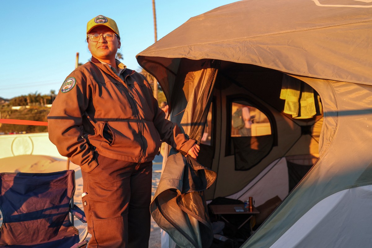 A member of the California Conservation Corps enjoys the sunset from her sleeping tent at the first responders base camp set up at Zuma Beach