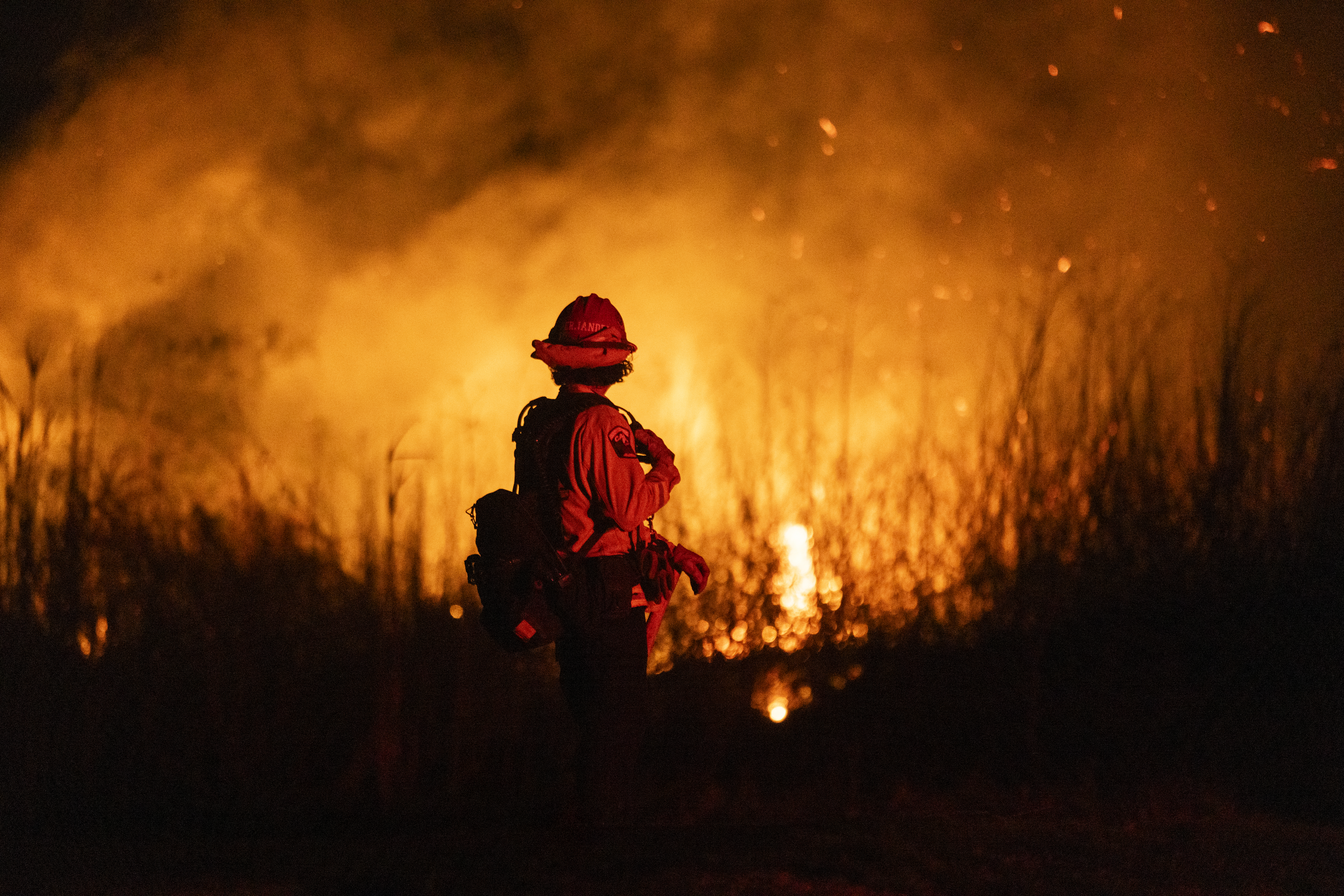 A firefighter monitors a fire in California