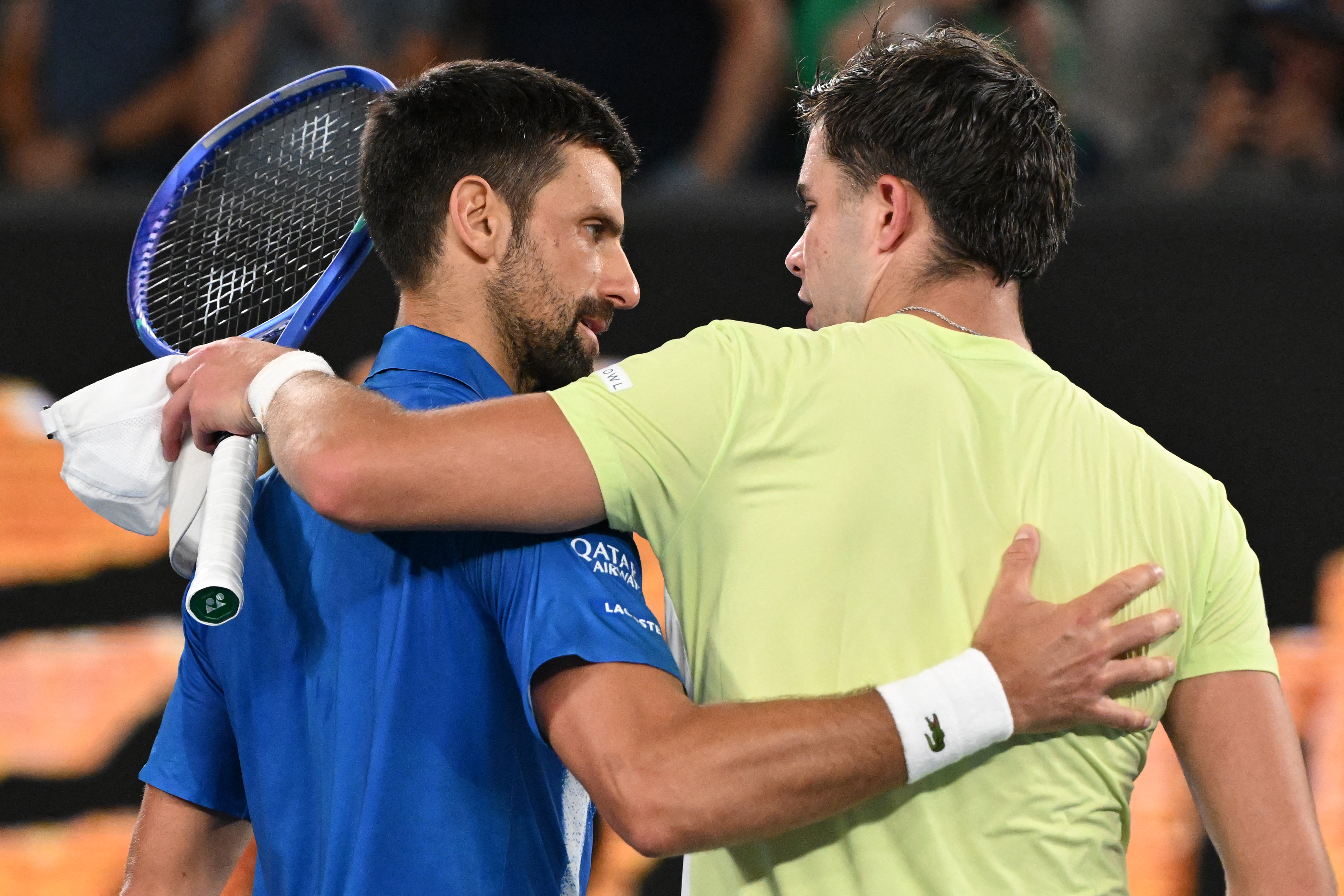 Serbia's Novak Djokovic (L) speaks with Portugal's Jaime Faria after his victory during their men's singles match on day four of the Australian Open tennis tournament in Melbourne on January 15, 2025. (Photo by WILLIAM WEST / AFP) / -- IMAGE RESTRICTED TO EDITORIAL USE - STRICTLY NO COMMERCIAL USE --