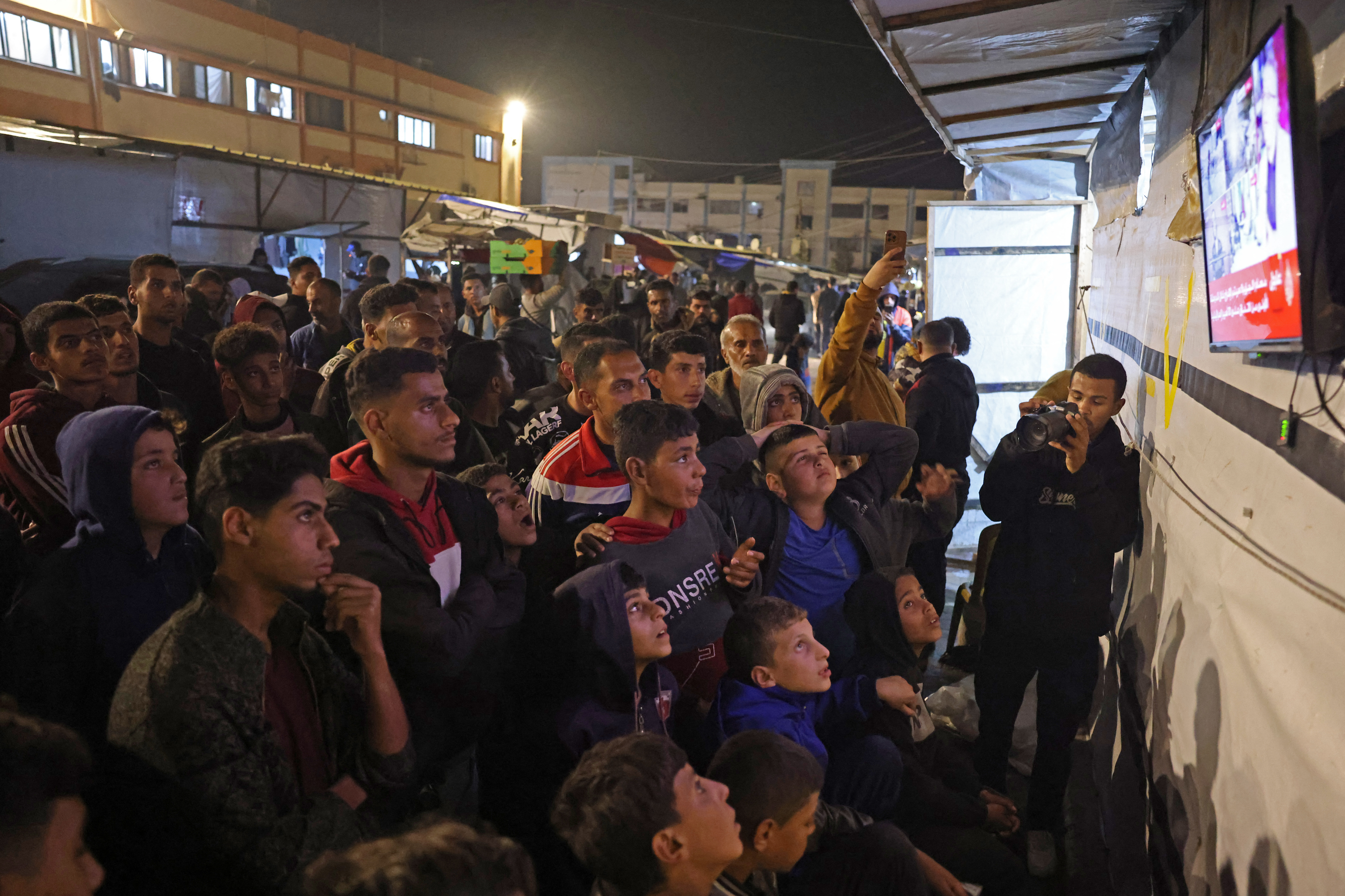 Palestinians react as they wait for news of a ceasefire deal with Israel