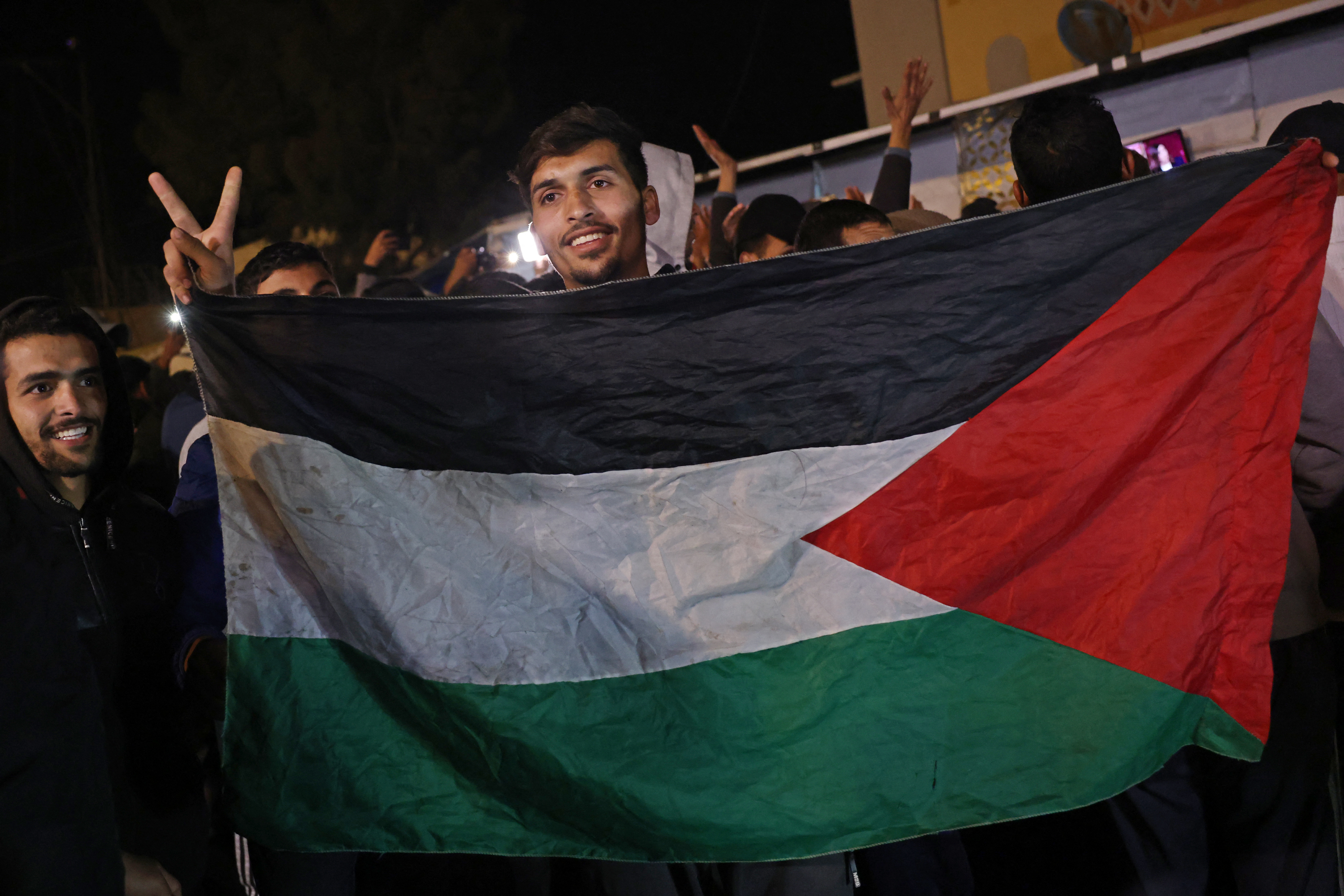 Palestinians react as they wait for news of a ceasefire deal with Israel