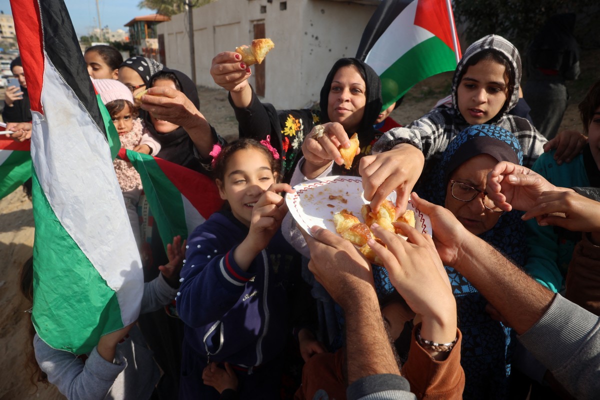 Displaced Palestinians share sweets as they return to Rafah in the southern Gaza Strip on January 19, 2025, hours after a ceasefire deal in the war between Israel and the Palestinian militant group Hamas was expected to be implemented.