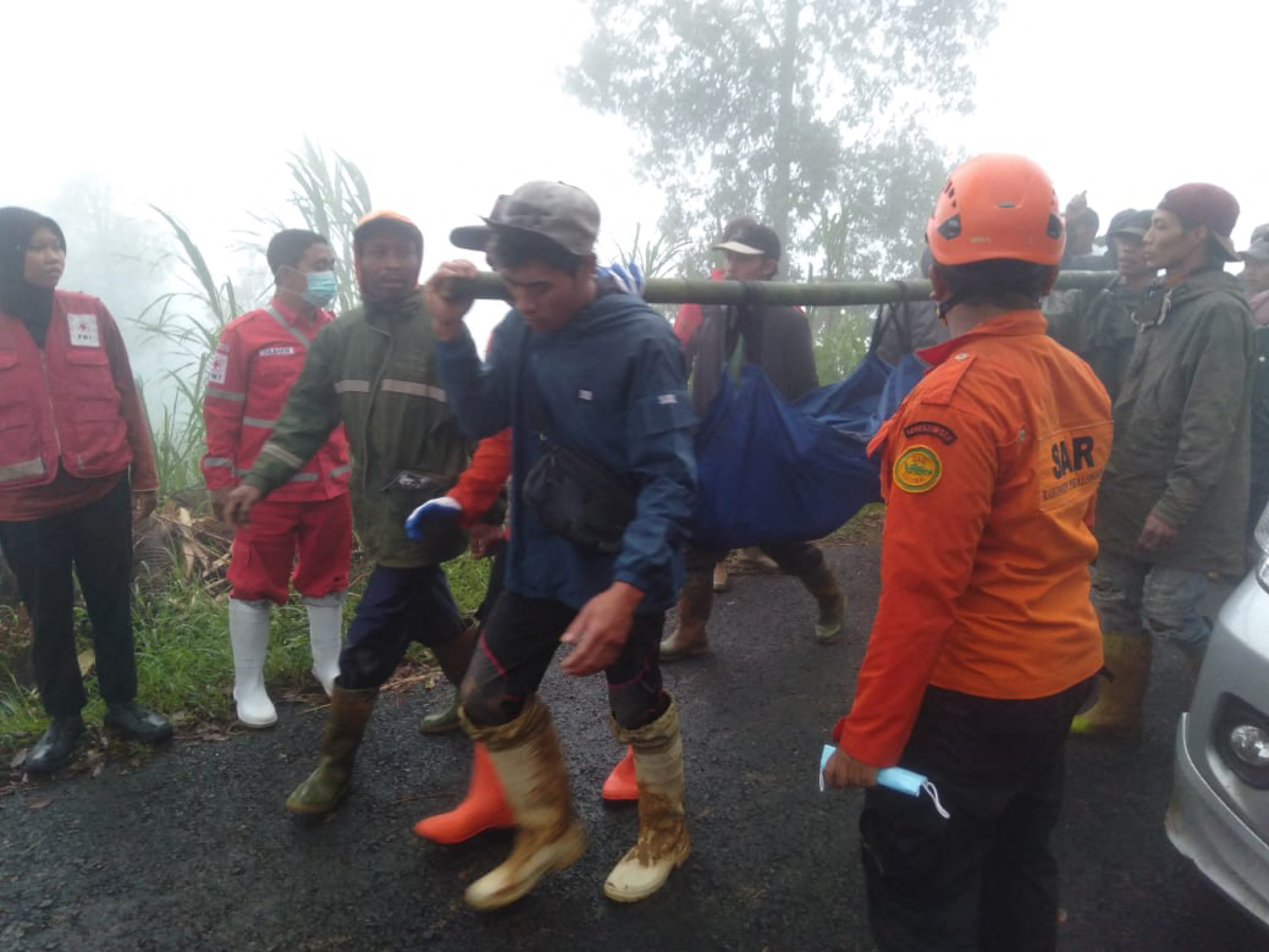 In this handout picture taken and released on January 21, 2025, by the Indonesias Disaster Mitigation Agency shows, rescueers and villagers evacuate victims of a landslide at Kasimpar Village in Pekalongan, Central Java. At least 16 people have been killed and three more are missing after a landslide triggered by heavy rain in Indonesias Central Java province, disaster officials said