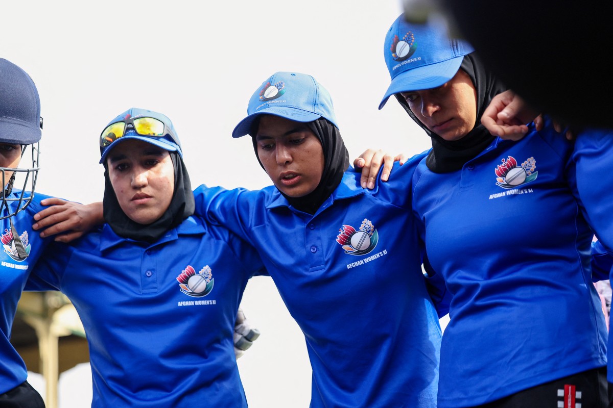 Afghanistan Women's XI players say a prayer before the cricket match