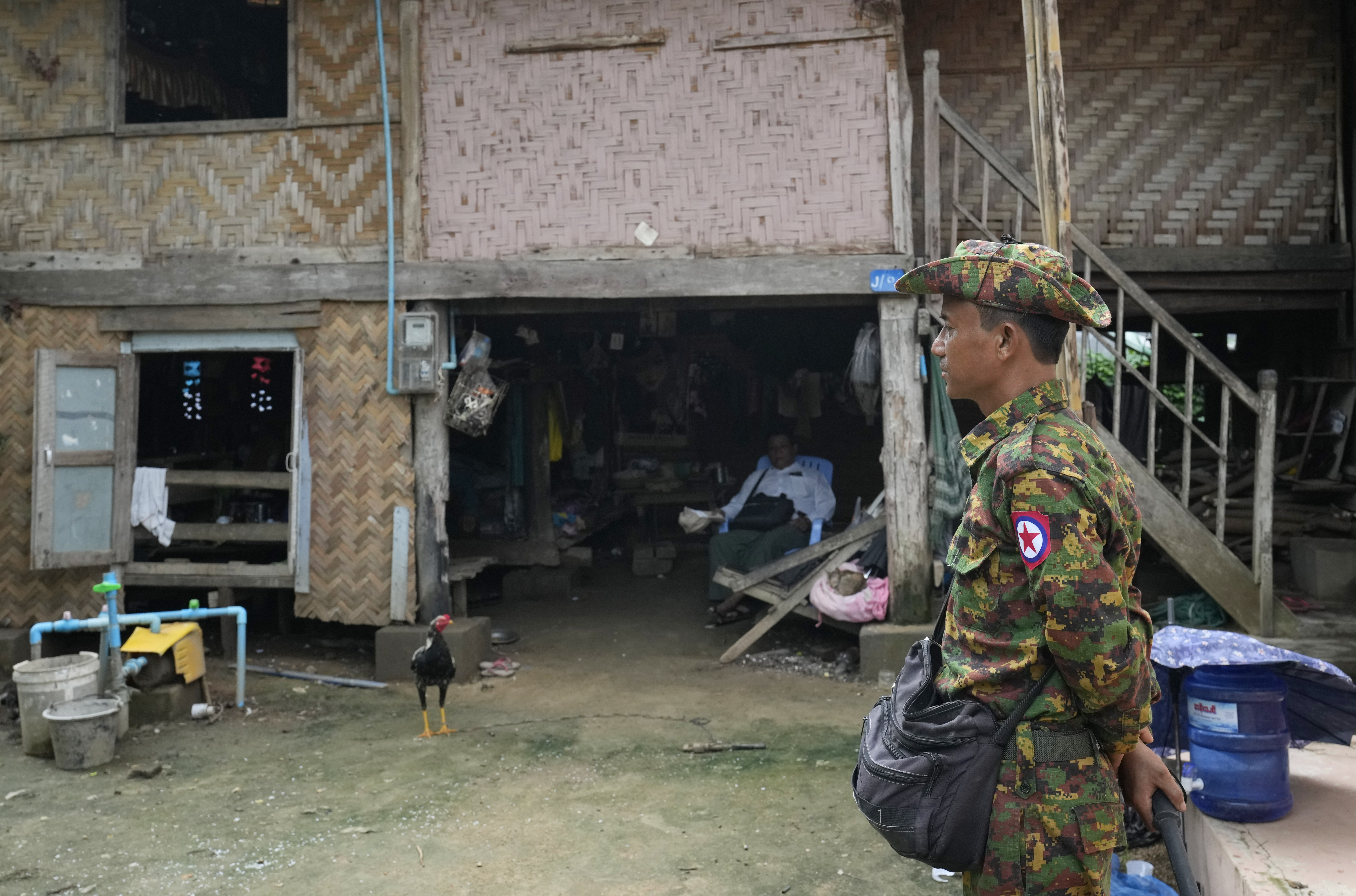 Soldiers provide a security while census enumerators collect information in Naypyitaw, Myanmar Tuesday, Oct. 1, 2024 as the country holds a national census to compile voter lists for a general election and to analyse population and socioeconomic trends. (AP Photo/Aung Shine Oo)