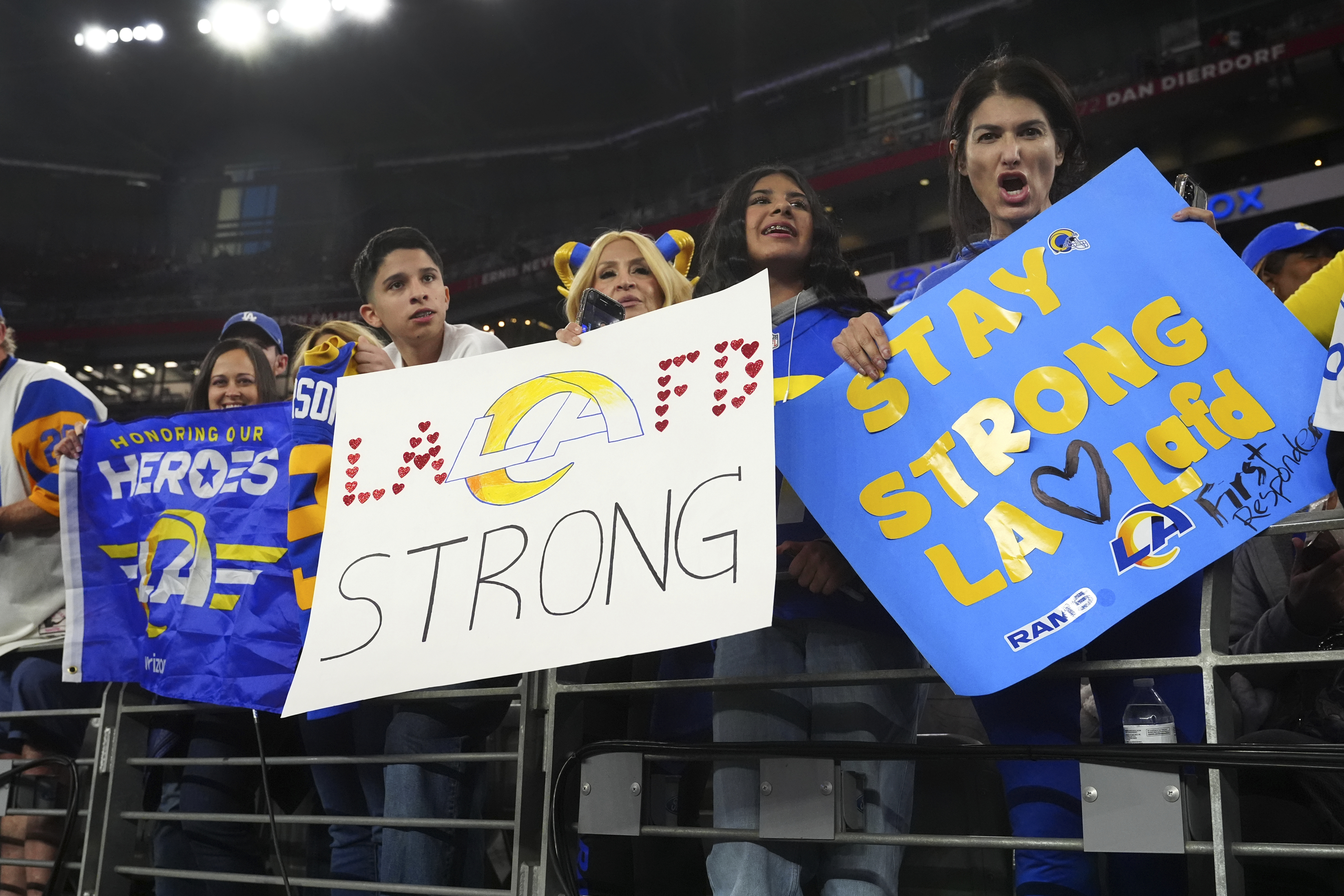 Los Angeles Rams fans hold signs in support of the community and first responders before their NFL wild-card game against the Minnesota Vikings in Glendale, Arizona