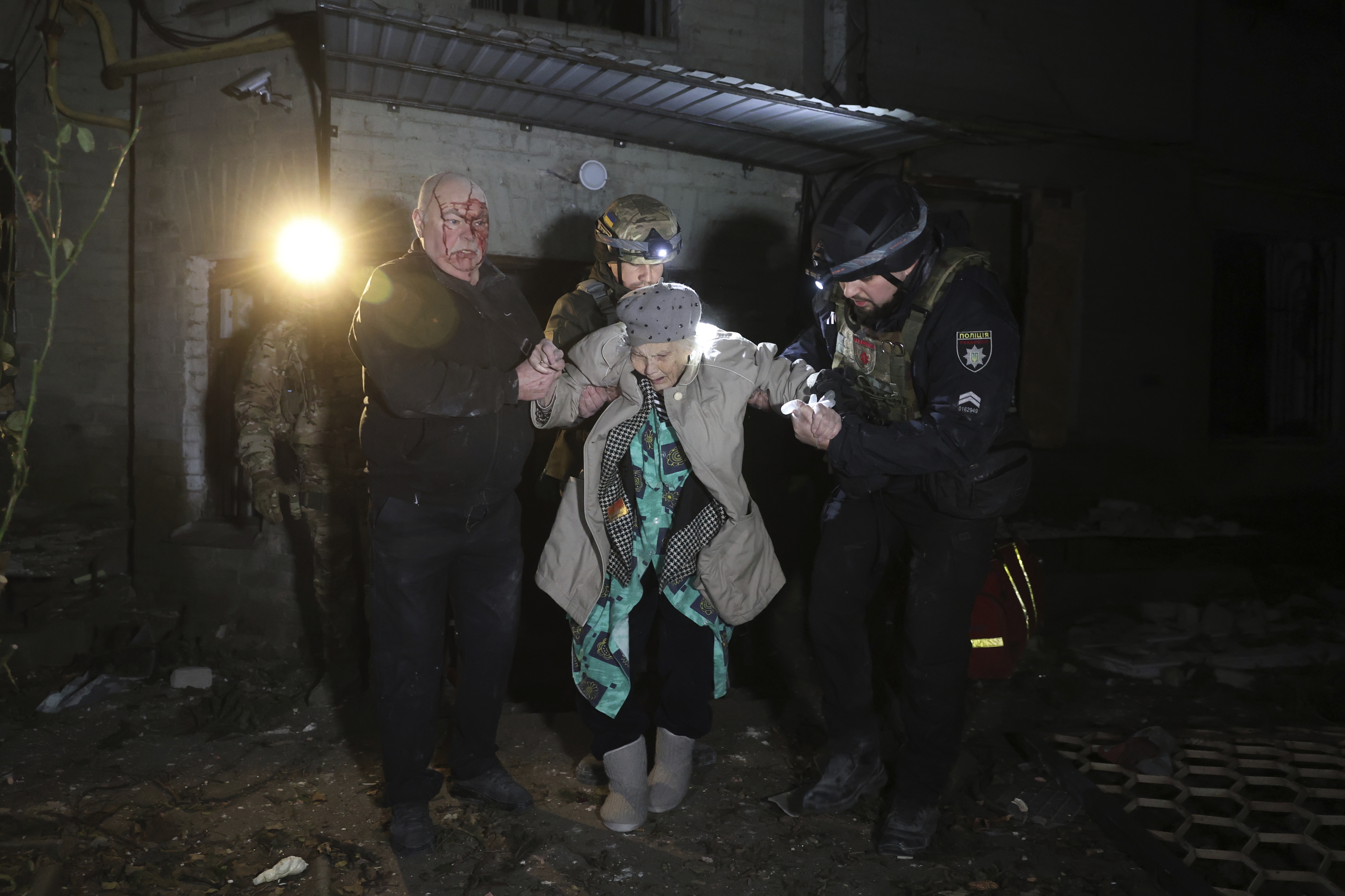 Rescuers help elderly residents leave their damaged home after a missile attack.