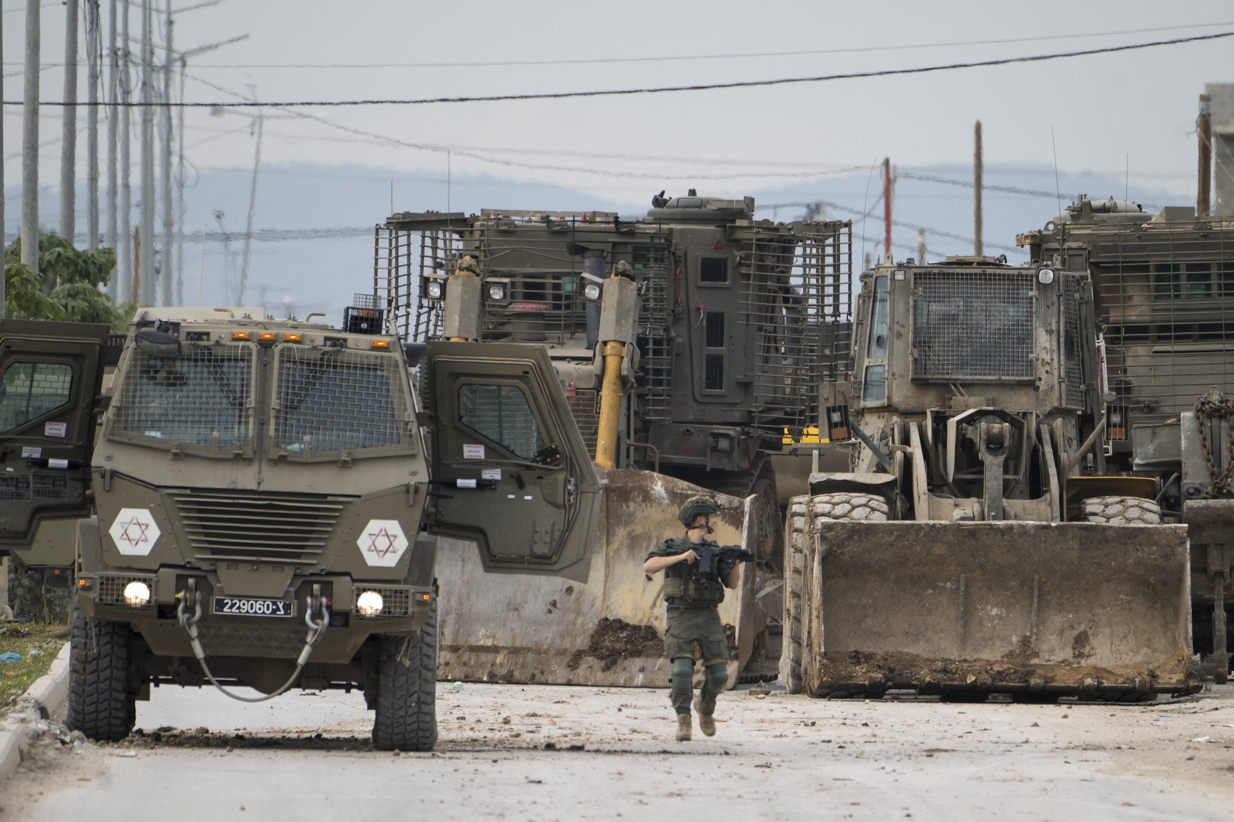 Israeli army vehicles are seen during a military assault on the West Bank city of Jenin on Wednesday [Majdi Mohammed/AP]