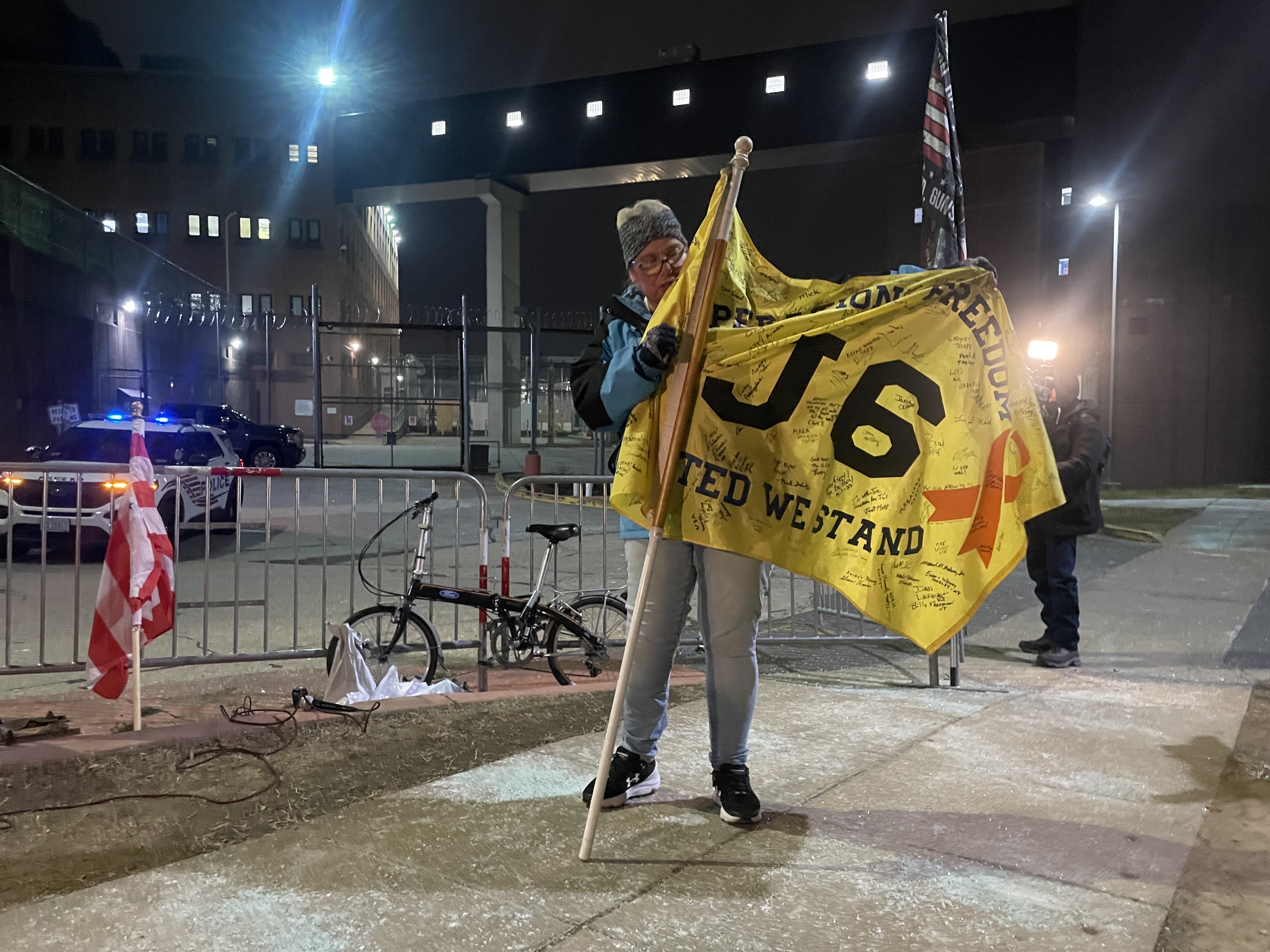 A woman holds a flag in front of DC Central Detention Center in support of January 6 prisoners in Washington, DC, the United States [Joseph Stepansky/Al Jazeera]
