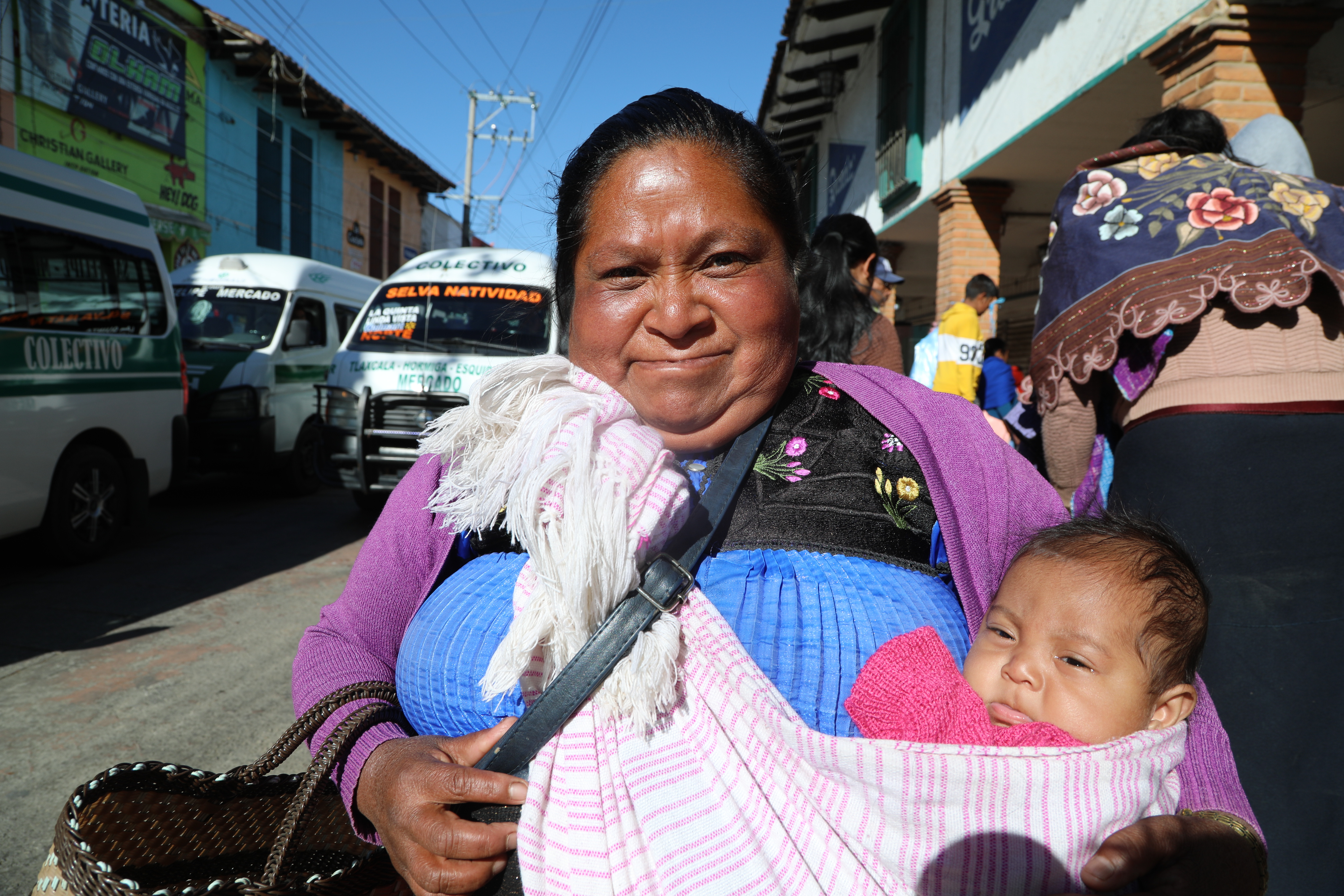 Manuela Dias holding a baby in a fabric sling