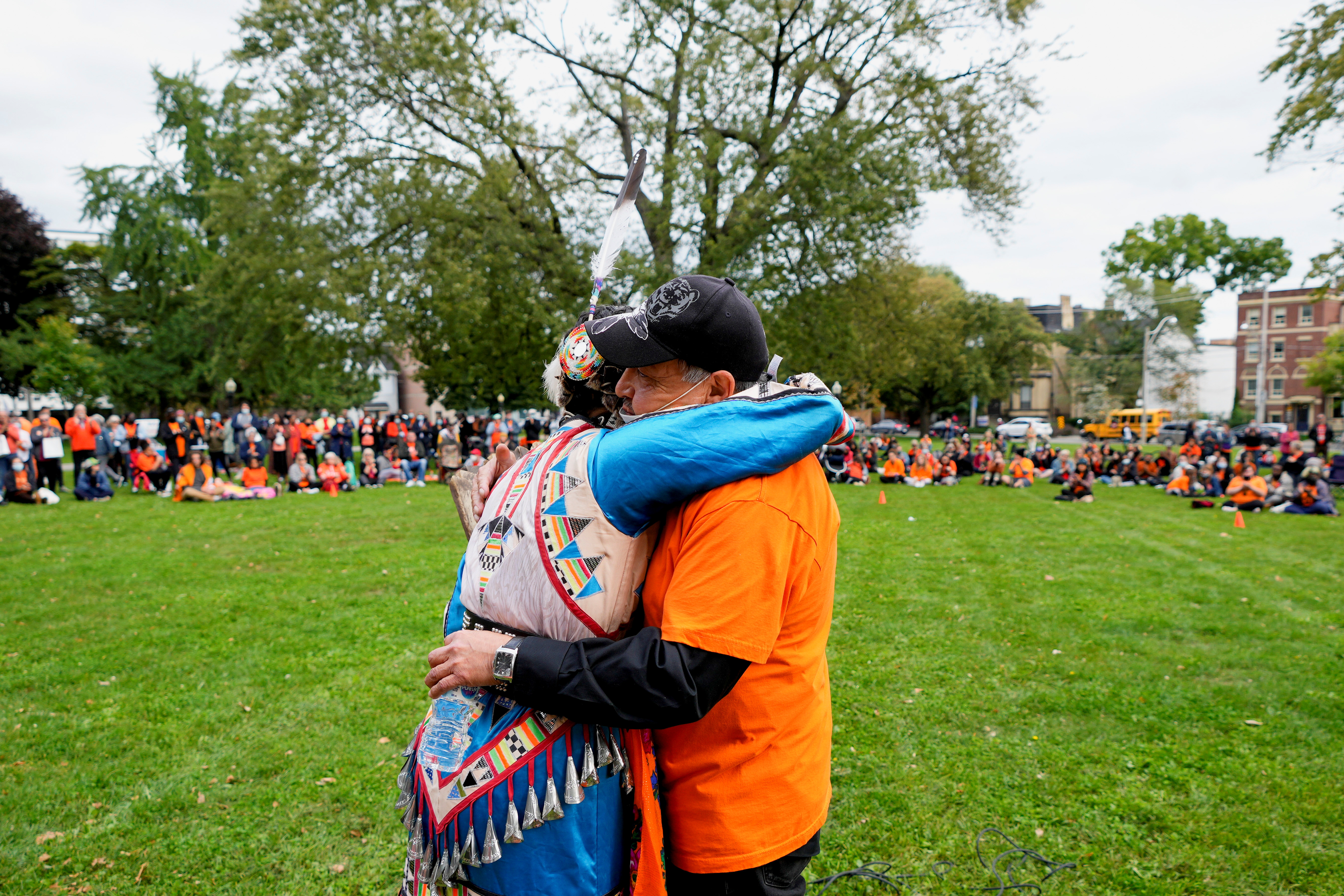 People hug at a ceremony to honour residential school survivors