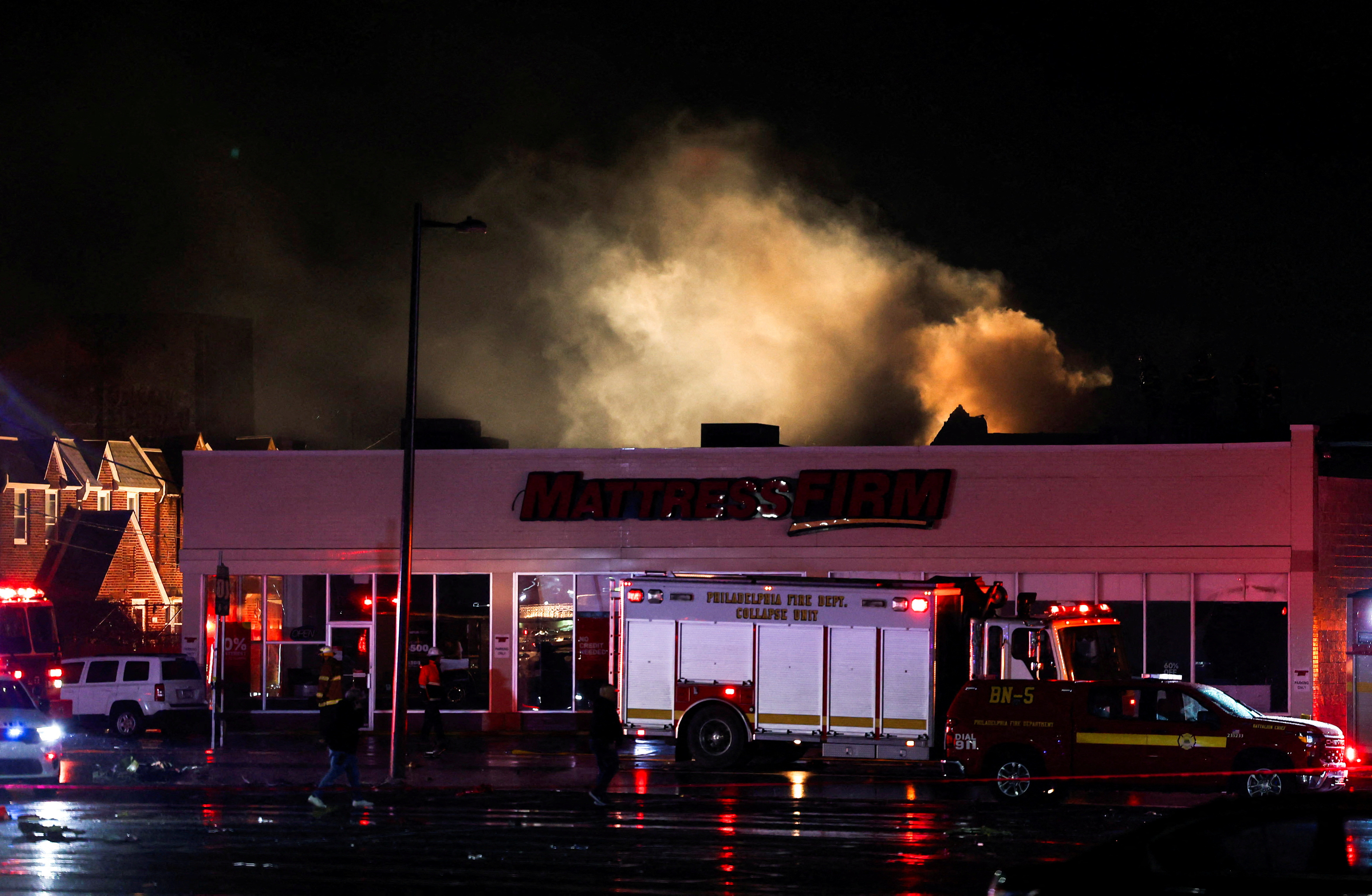 Smoke rises as emergency personnel operate in the aftermath of a plane crash in Philadelphia, Pennsylvania, U.S.